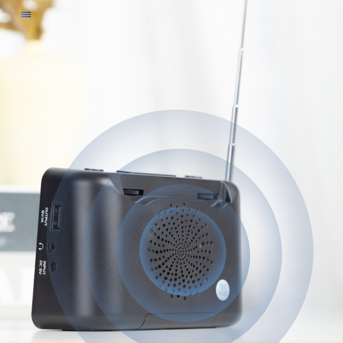 Ein schwarzes Radio mit Antenne, das Schallwellenkreise zeigt, auf weißem Hintergrund.