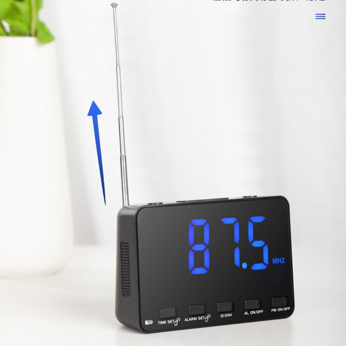 Ein schwarzer digitaler Wecker mit blauem Display, das 87,5 MHZ und eine Antenne anzeigt.