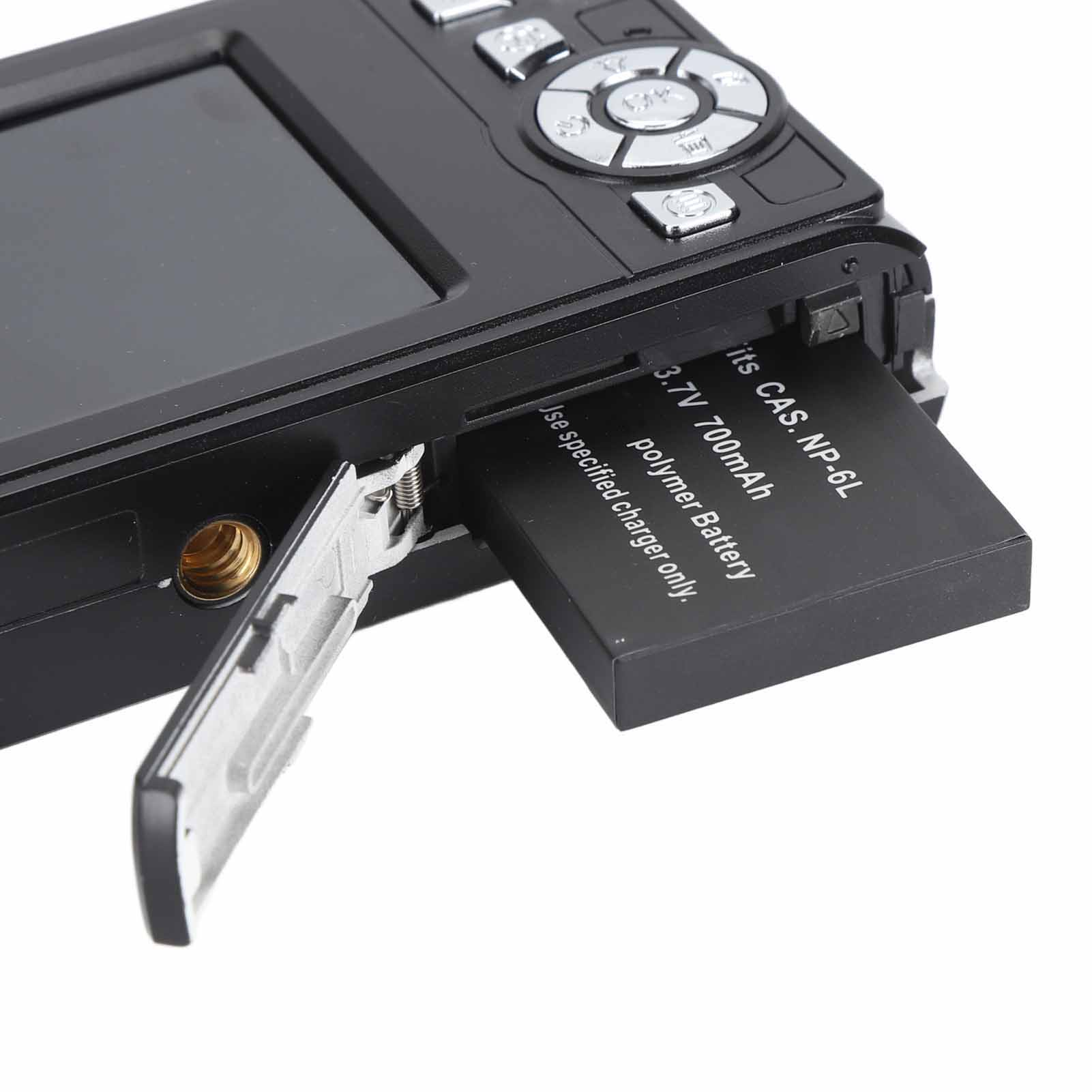 Eine schwarze Digitalkamera mit offenem Batteriefach und teilweise eingesetzter Batterie, auf Weiß.