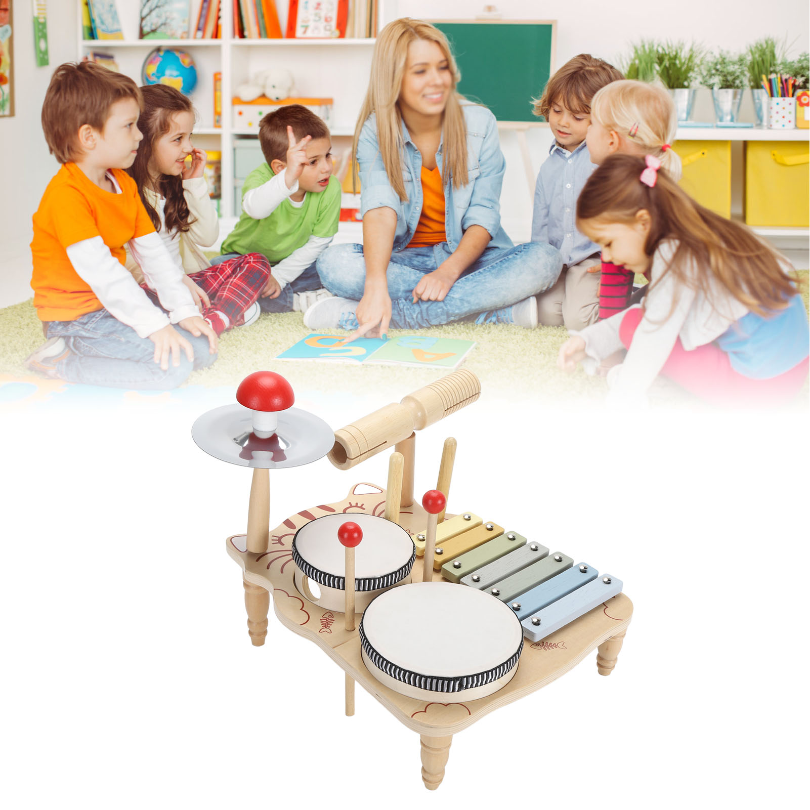 Kinder und eine Lehrerin. Ein Spielzeug-Schlagzeug steht im Vordergrund. Die Szene ist in einem Klassenzimmer.