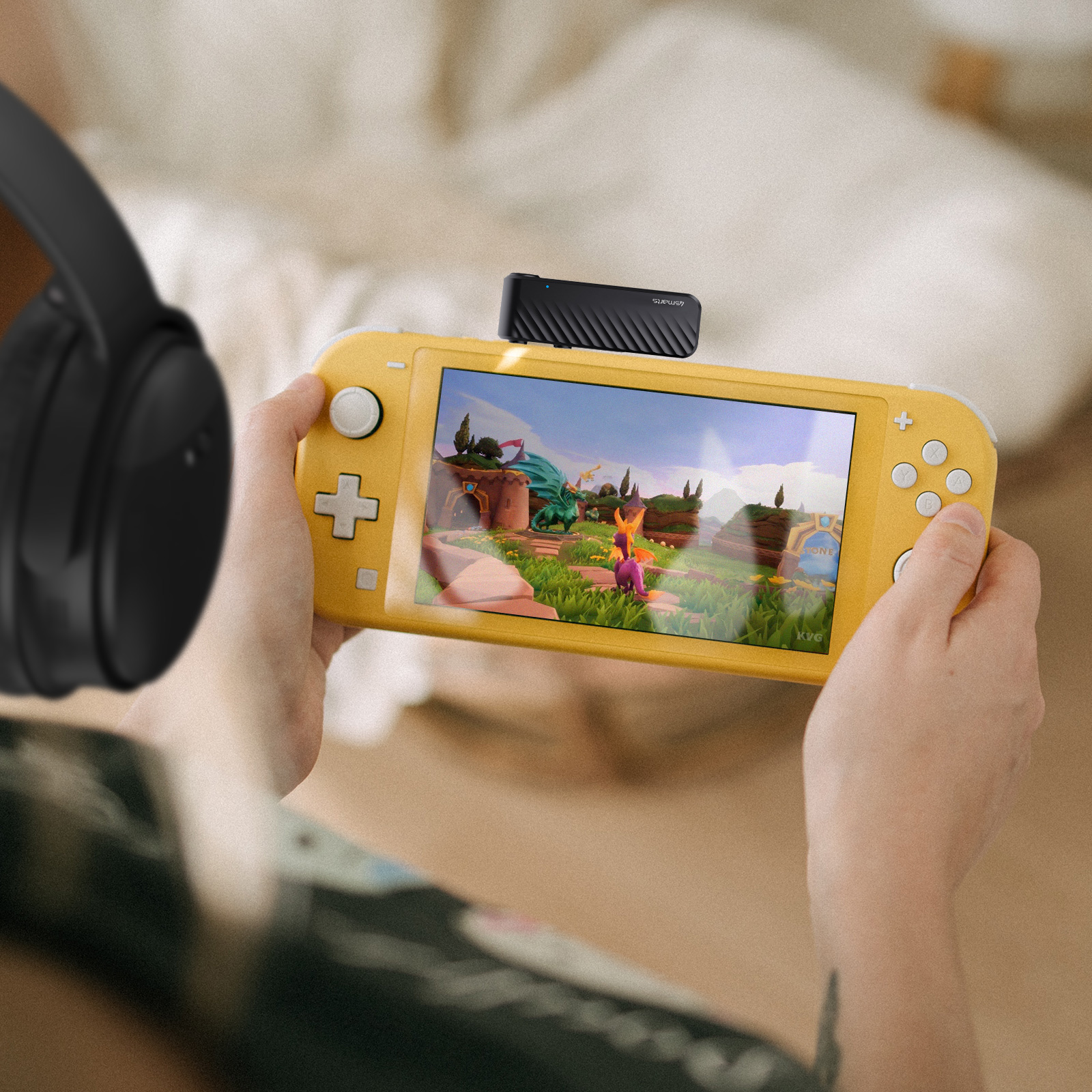 Person hält gelbe Nintendo Switch Lite und spielt. Schwarze Kopfhörer.