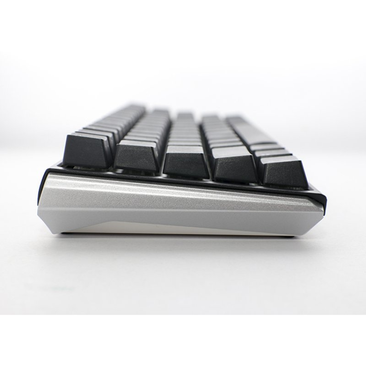 Primer plano de un teclado mecánico con teclas negras y marco plateado.