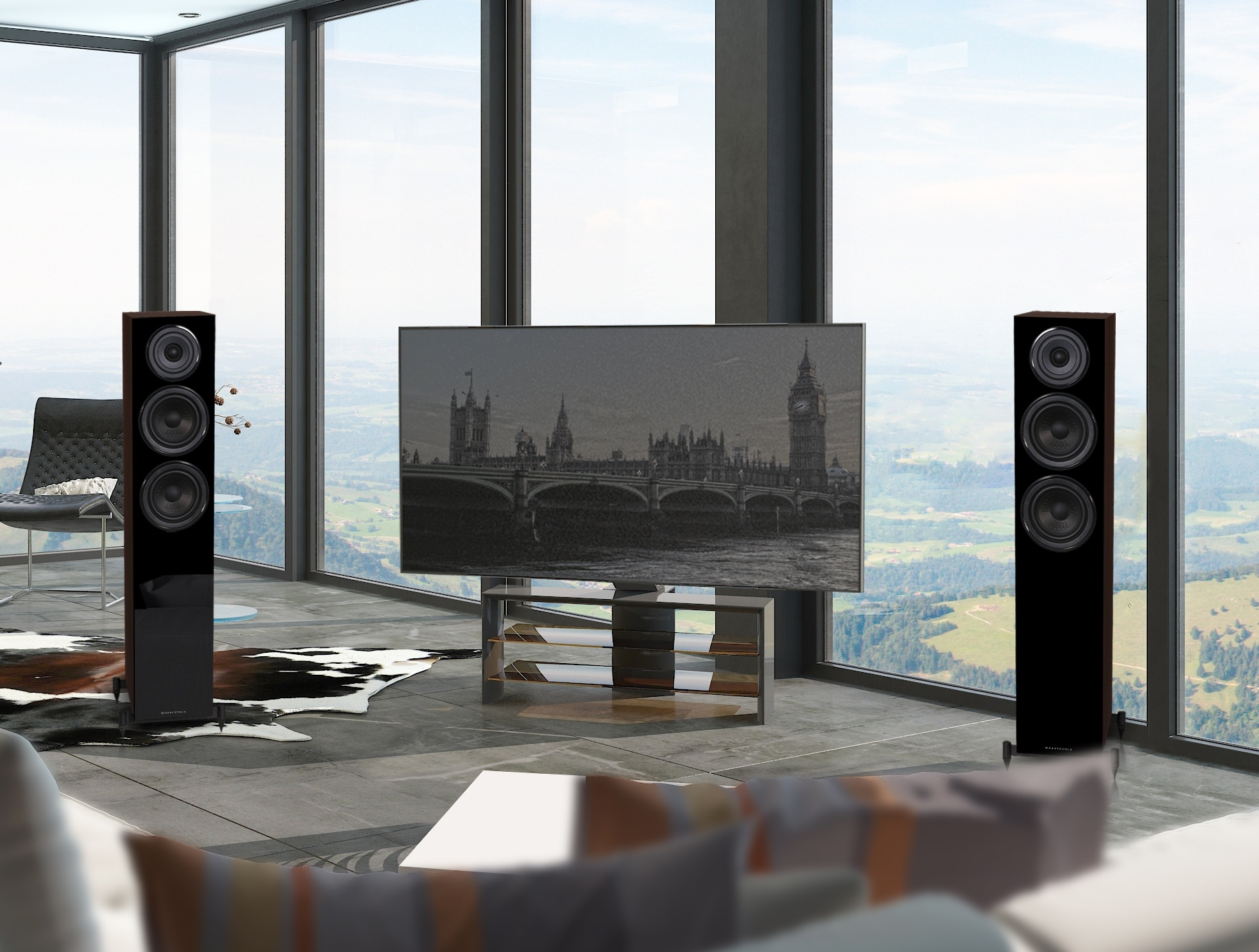 Salon avec grandes fenêtres, deux enceintes, une TV, un canapé et vue sur un paysage urbain.