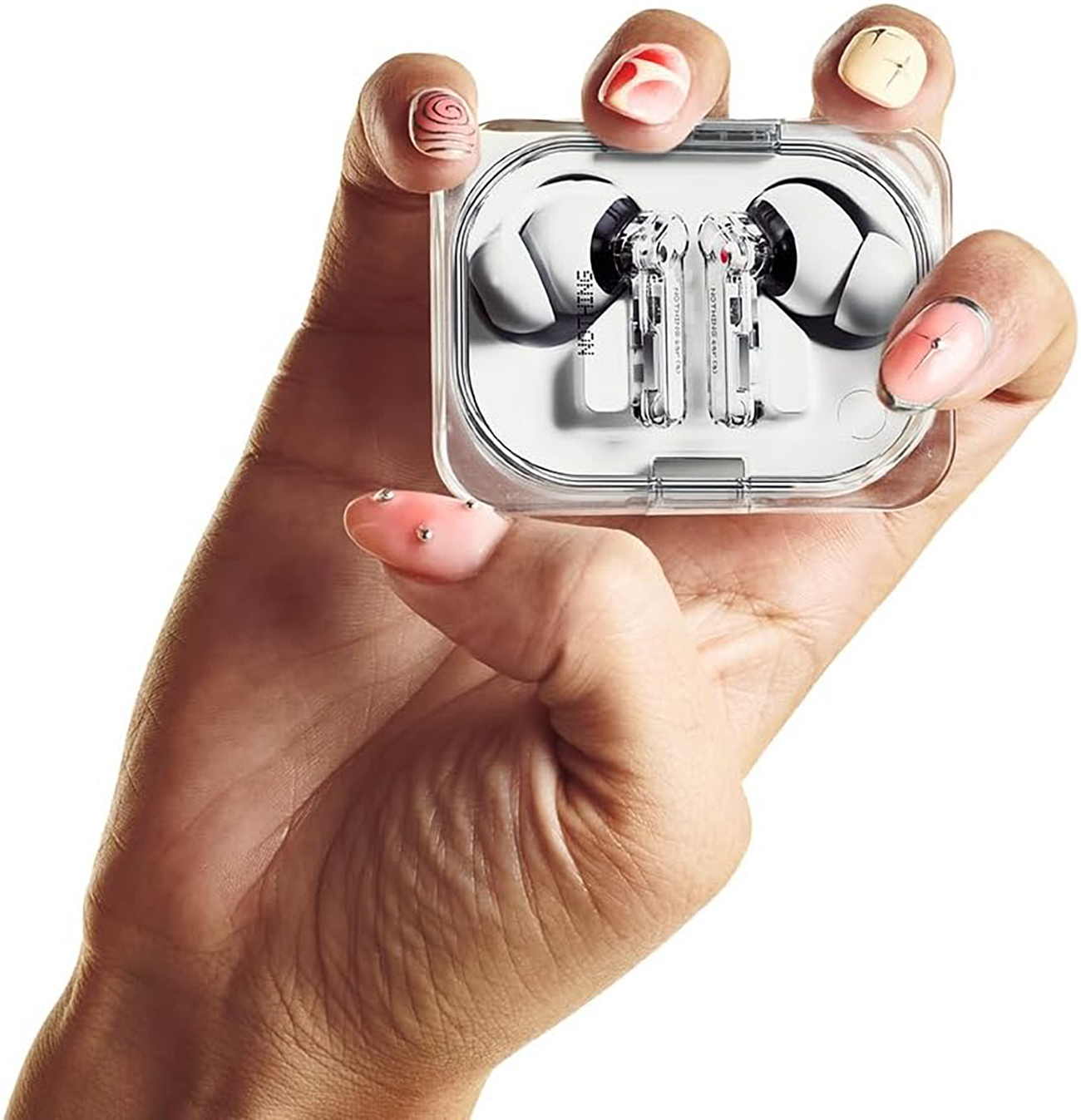 Dłoń trzyma przezroczyste etui z dwoma białymi słuchawkami. Różowe paznokcie.