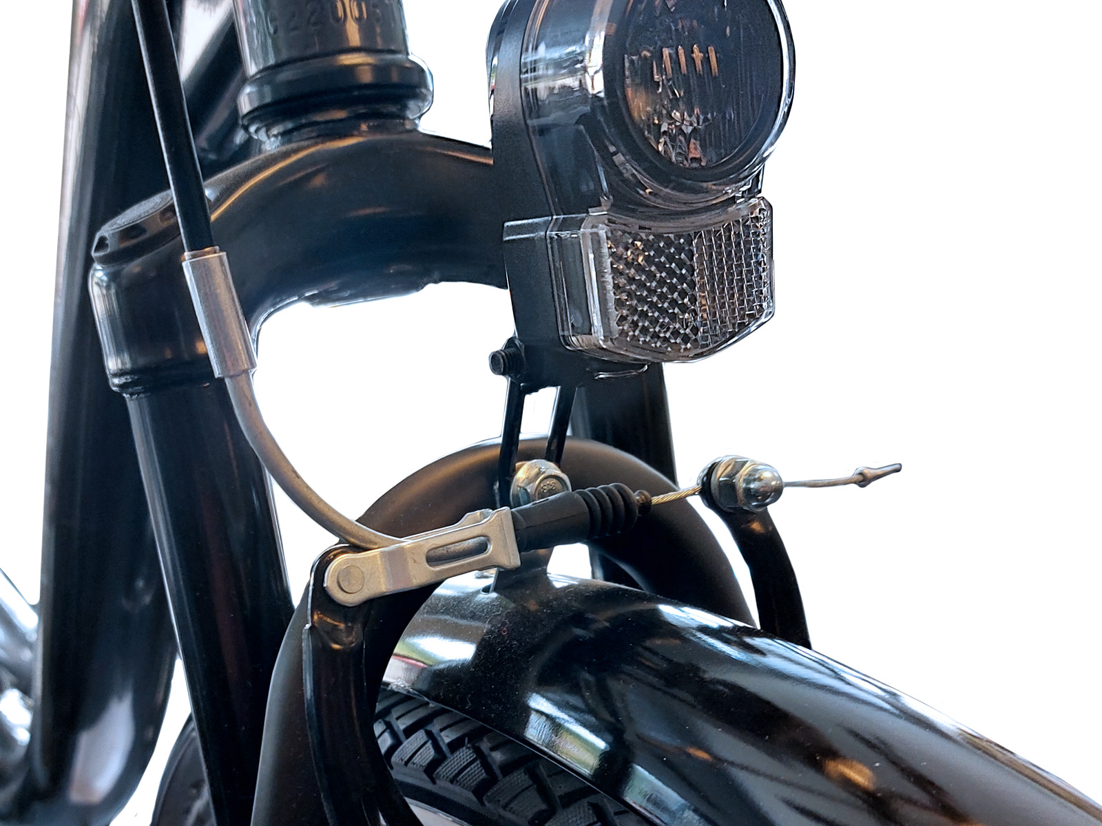 Close-up van de voorkant van een fiets, met de koplamp, remkabel en voorvork.