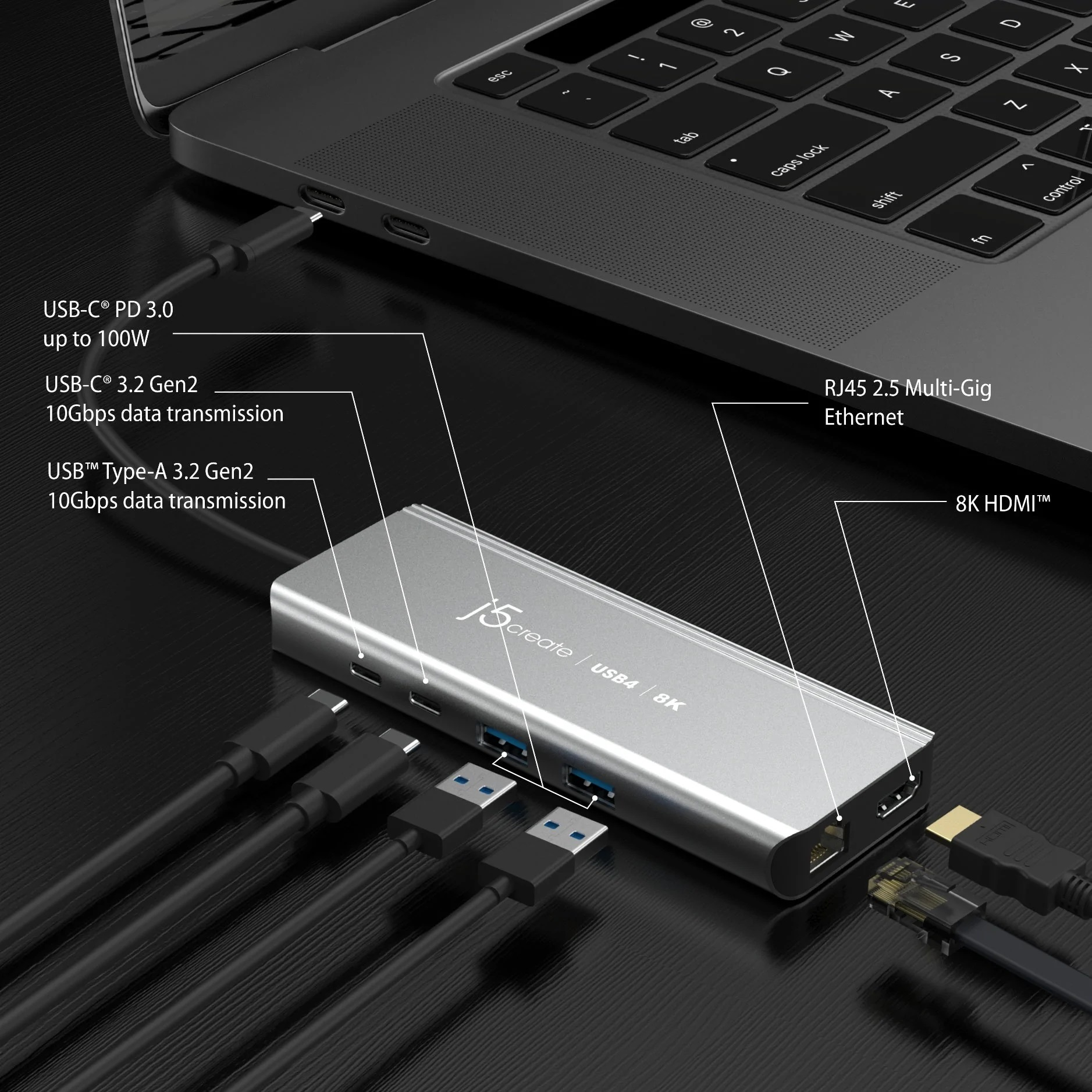 Ein silberner USB-Hub, der an einen Laptop angeschlossen ist. Viele Kabel sind angeschlossen.
