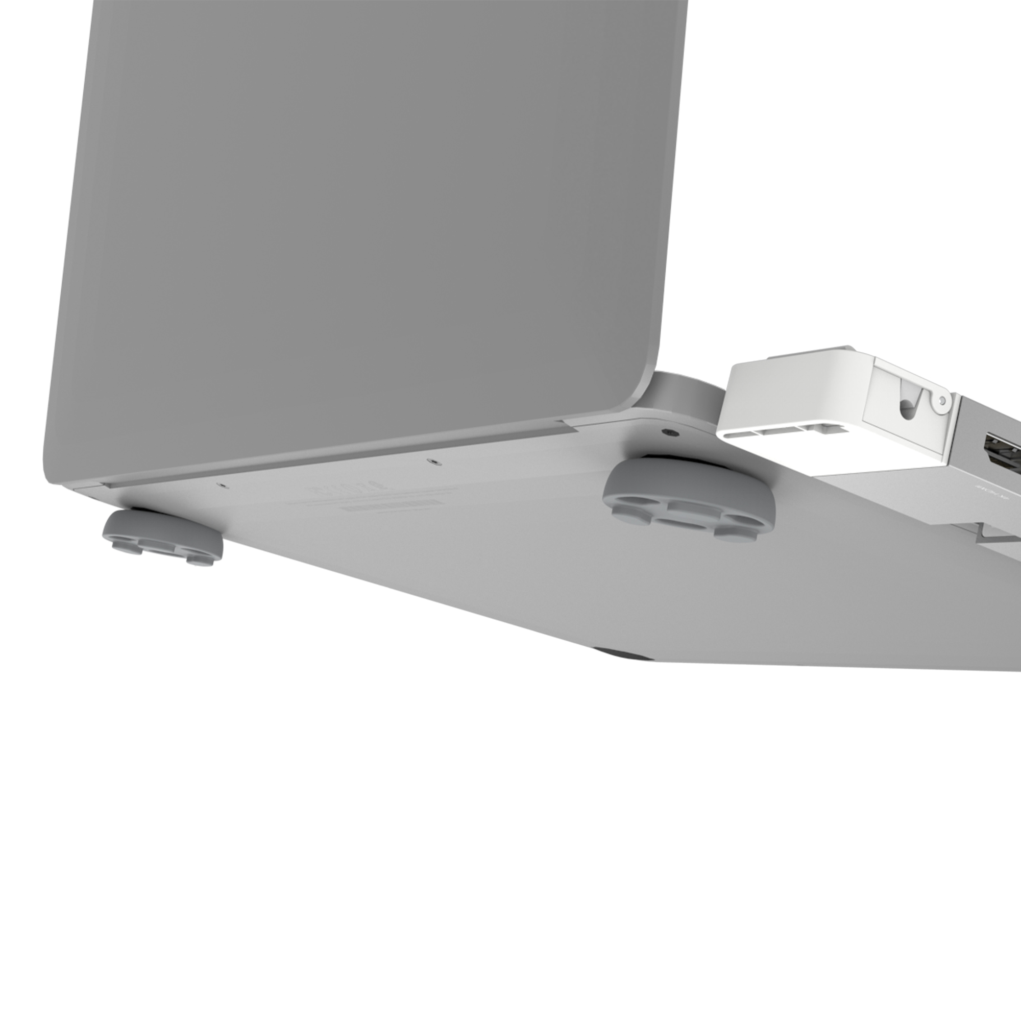 Laptopboden mit angeschlossenem Hub. Der Laptop ist grau, und der Hub ist weiß. Der Laptop steht auf grauen Pads.