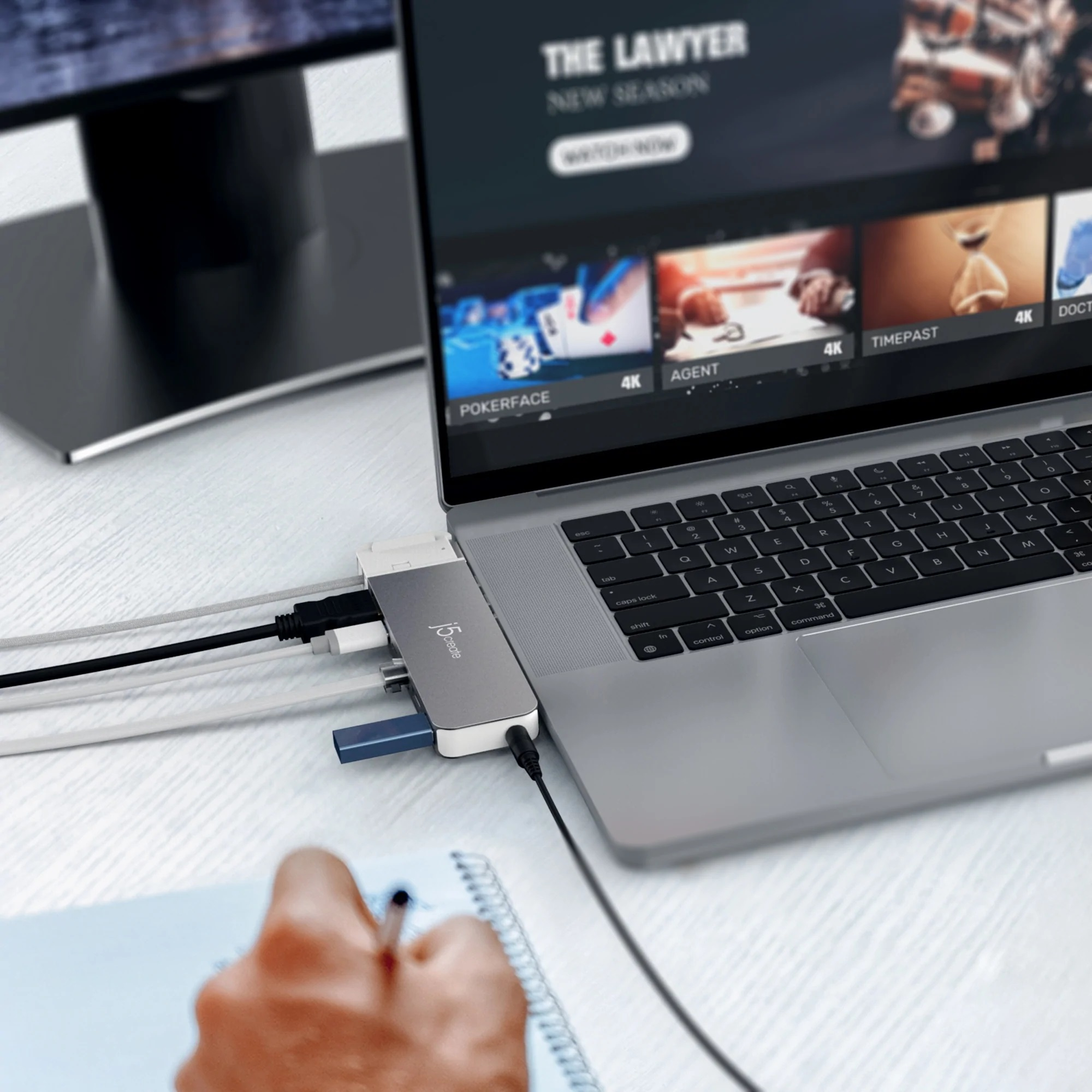 Laptop, verbunden mit Hub, mit verschiedenen Anschlüssen. Notizbuch und Monitor sind ebenfalls vorhanden.