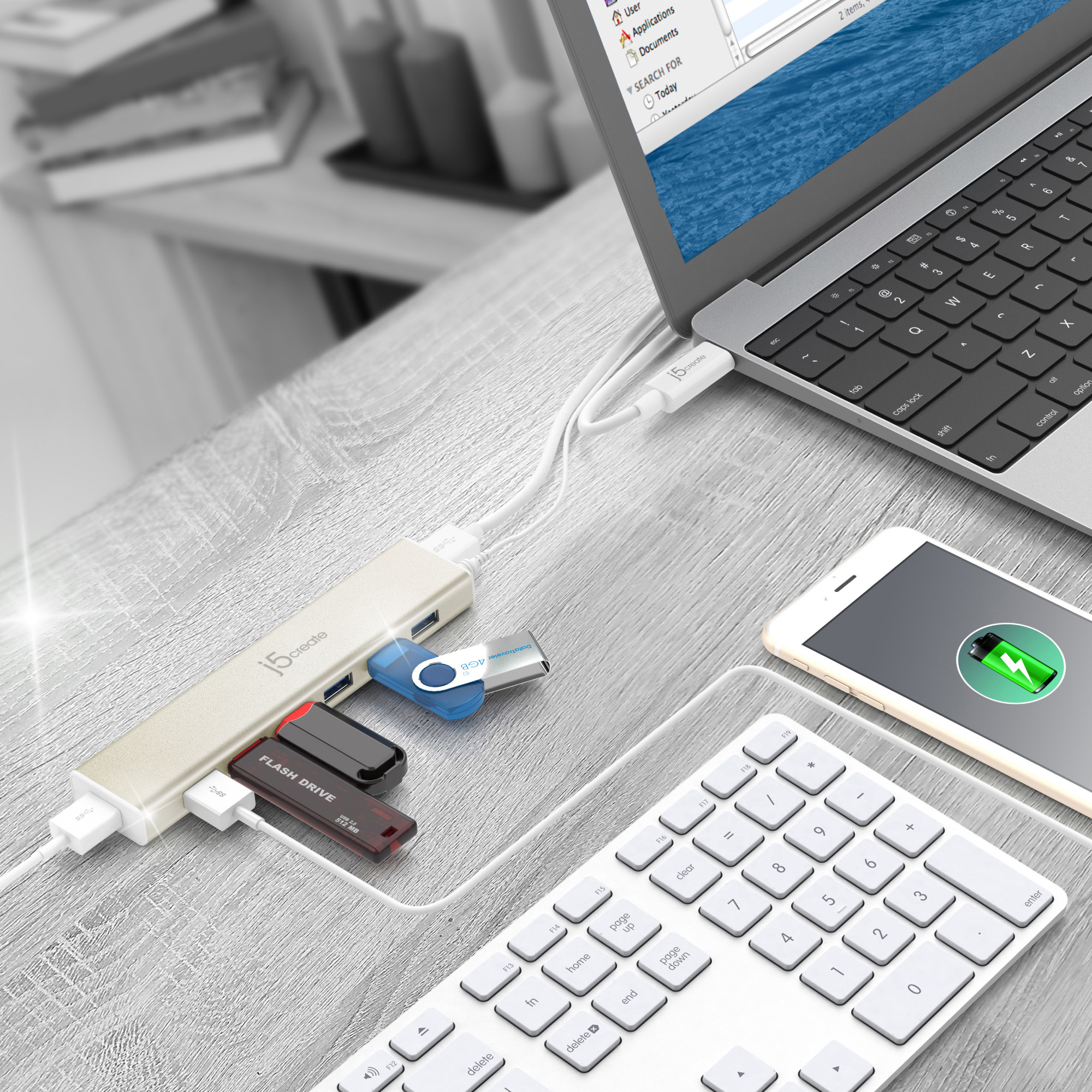 Ein USB-Hub, verbunden mit USB-Laufwerken, Telefon und Tastatur. Auf einem Holzschreibtisch.