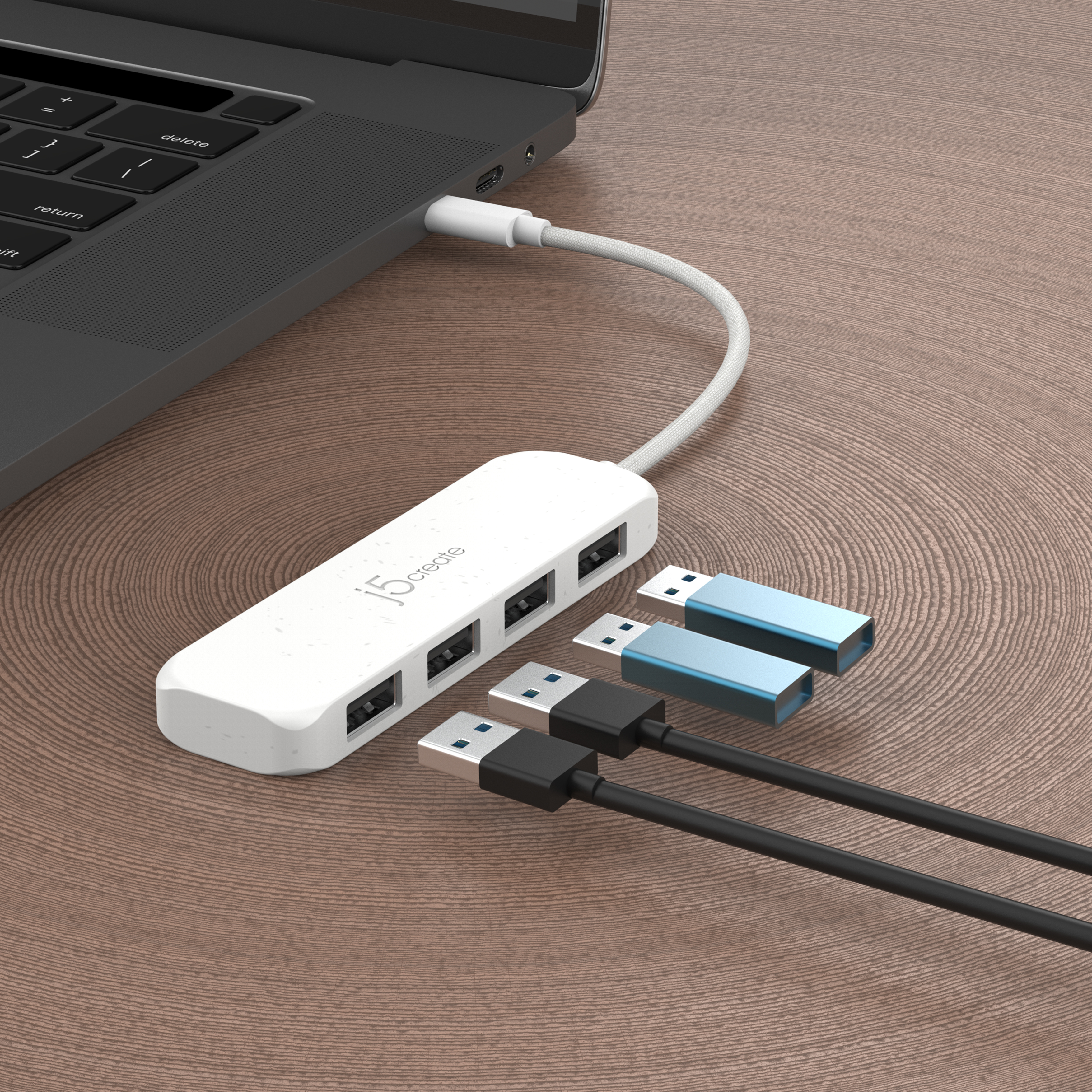 Ein weißer USB-Hub, der mit einem Laptop mit USB-Kabeln und -Anschlüssen verbunden ist.