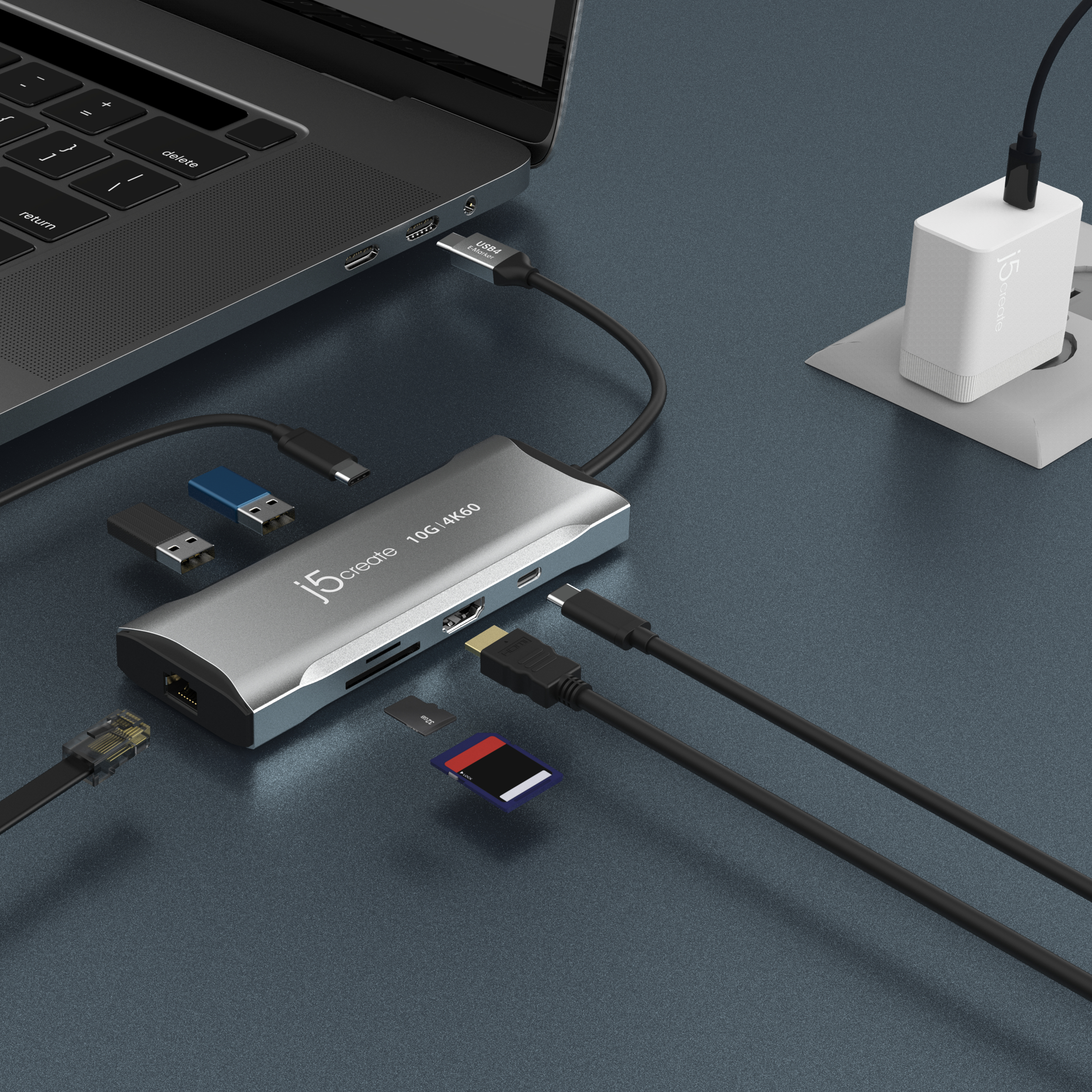 Ein Laptop mit einem silbernen Hub und mehreren angeschlossenen Geräten, einschließlich Kabeln und Karten.