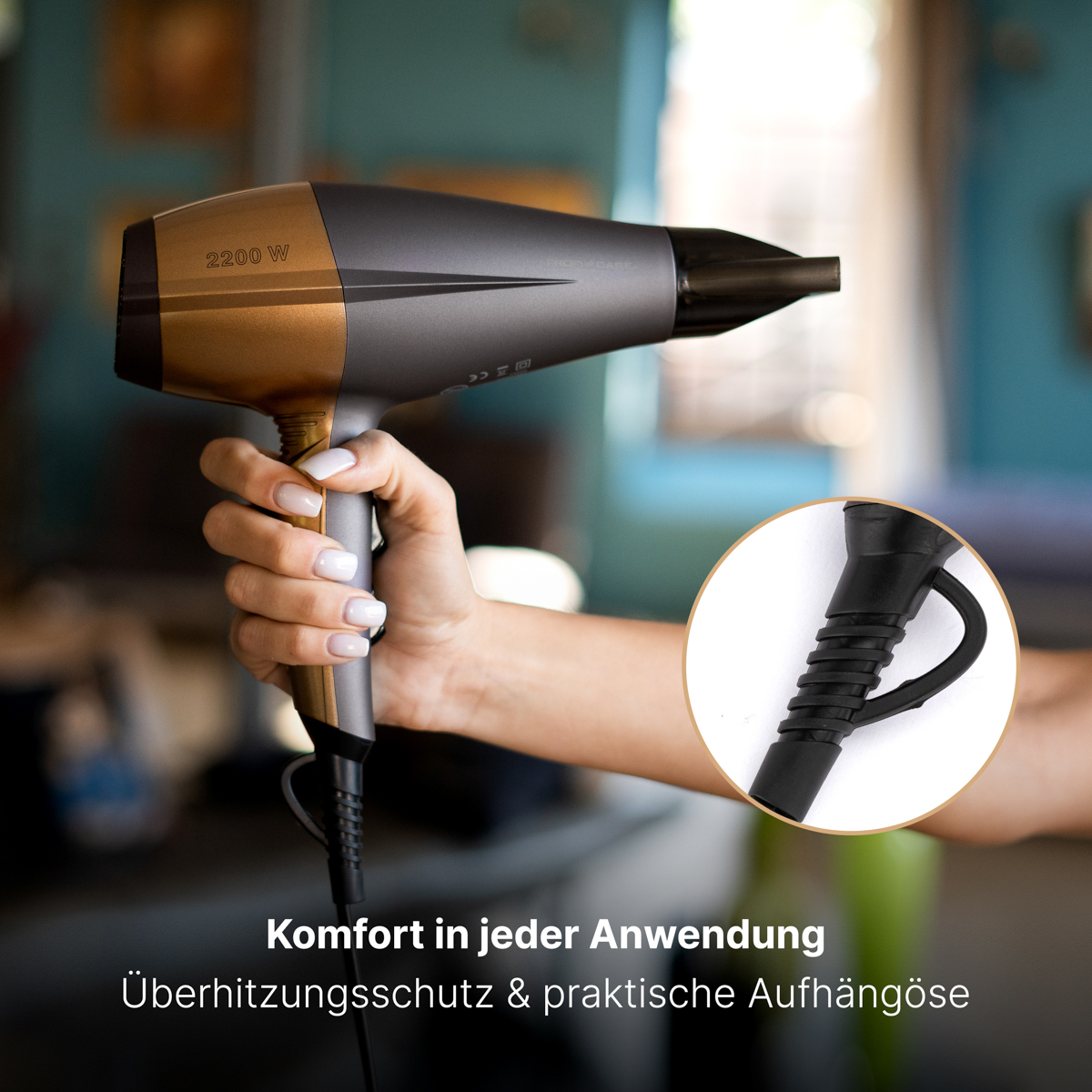 Ręka trzymająca szarą i złotą suszarkę do włosów. Tekst: Komfort w każdym użyciu, ochrona przed przegrzaniem.