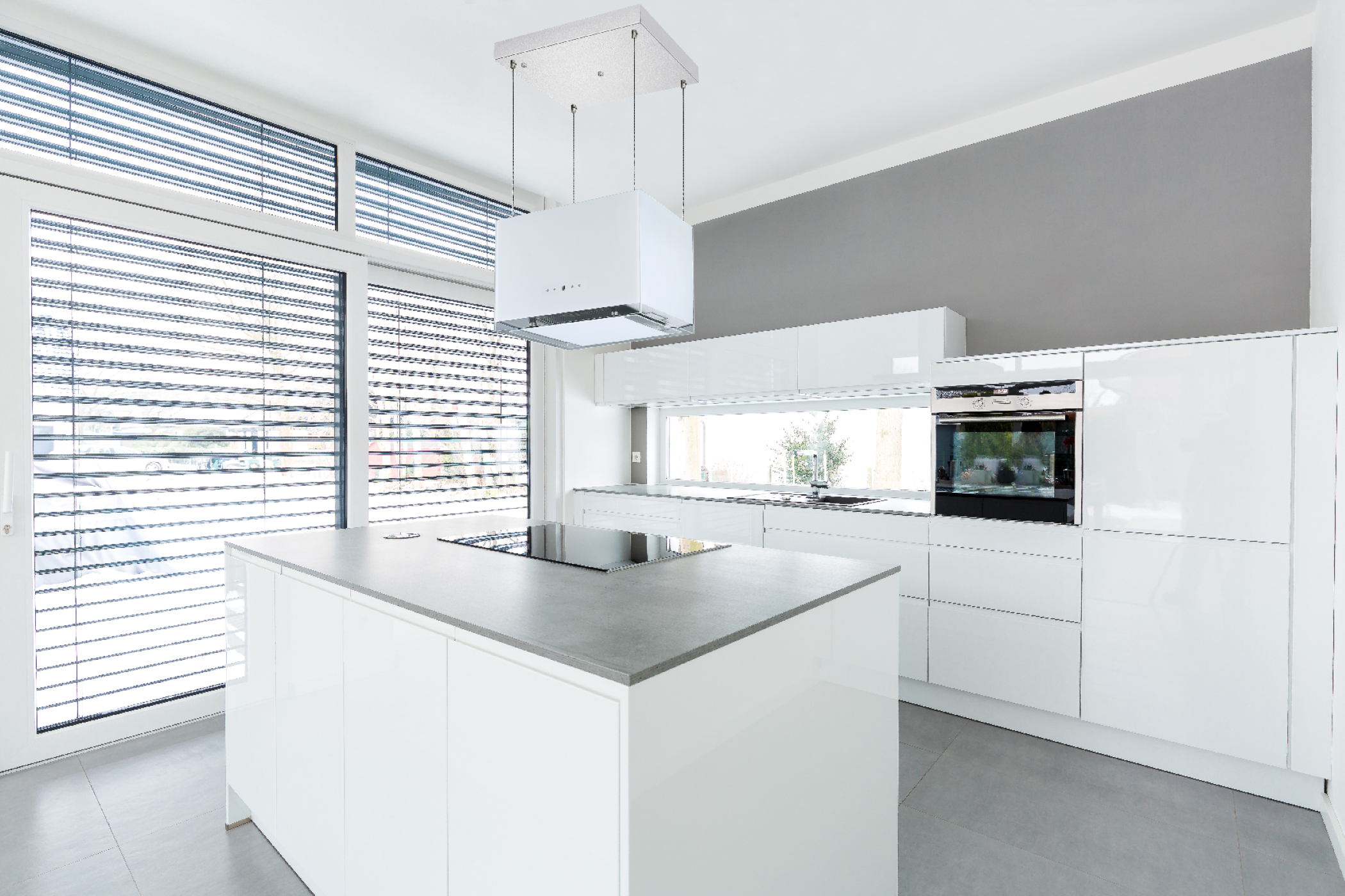 Modern white kitchen with island, window, and a range hood.