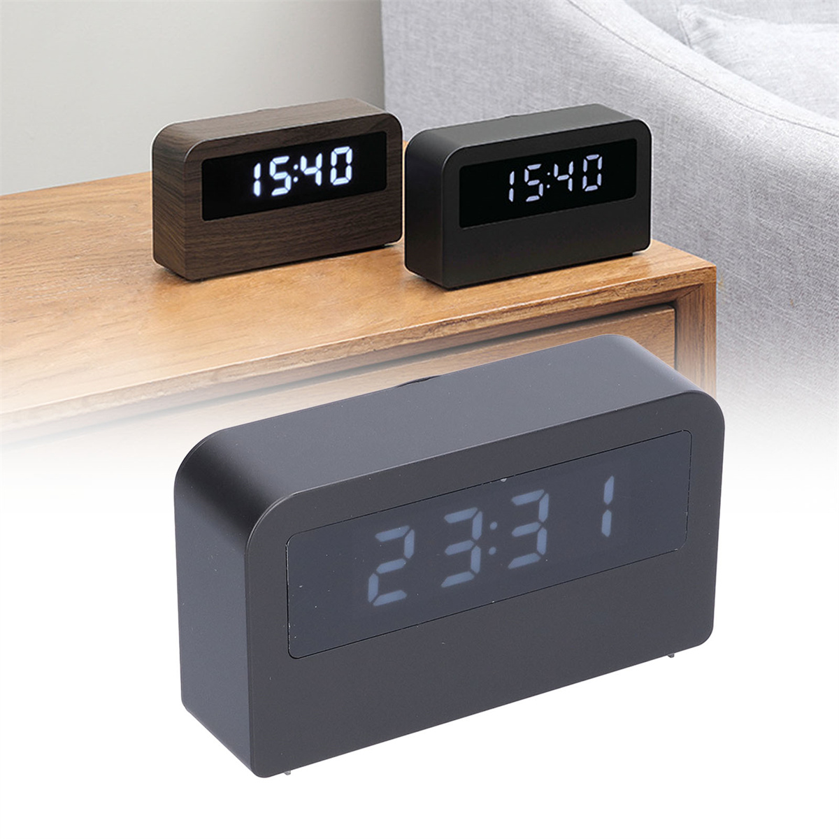 Drei Digitaluhren auf einem Tisch. Die Uhren zeigen die Zeit 15:40 und 23:31. Holz- und schwarze Farben.