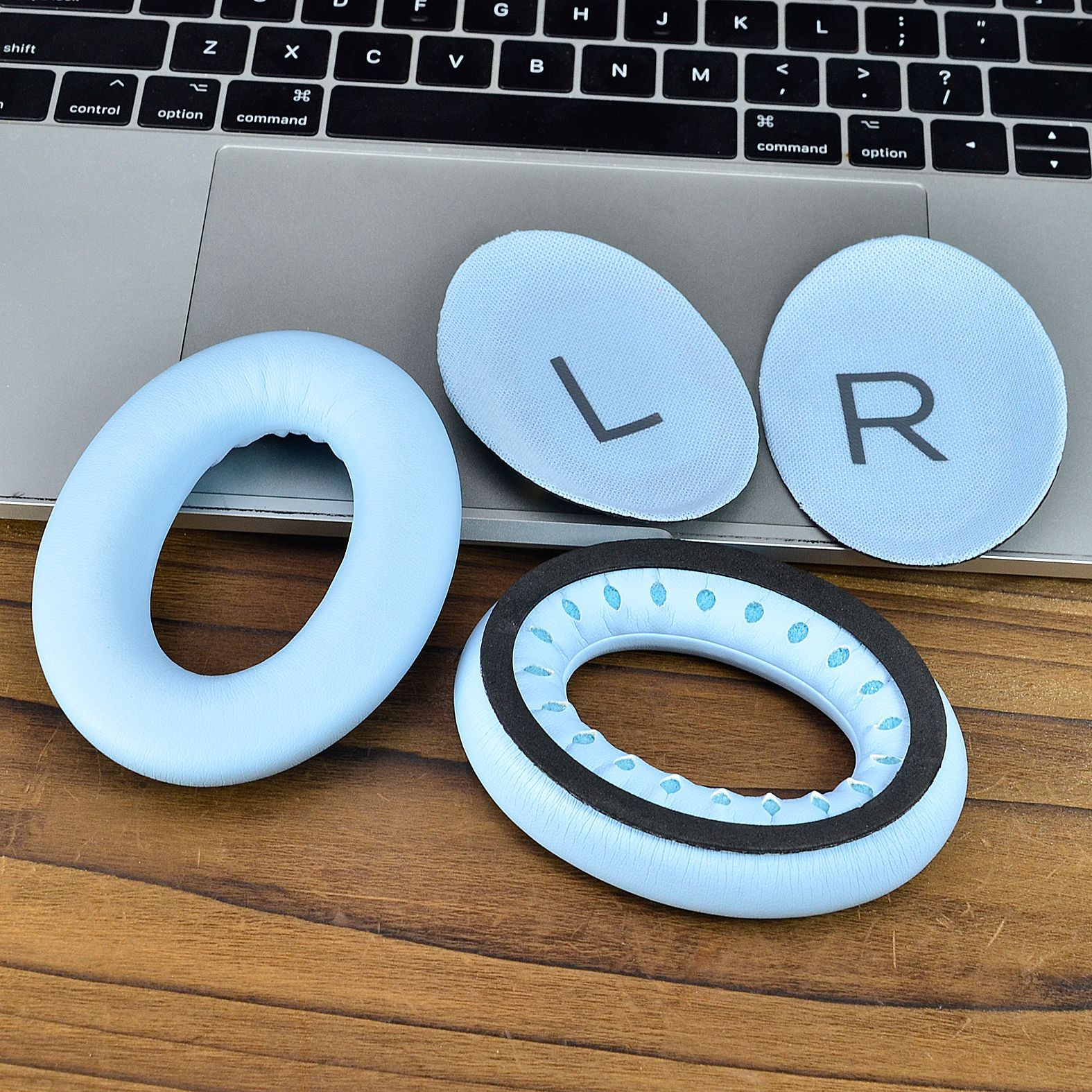 Niebieskie nauszniki, dwa z etykietami 'L' i 'R', na laptopie.