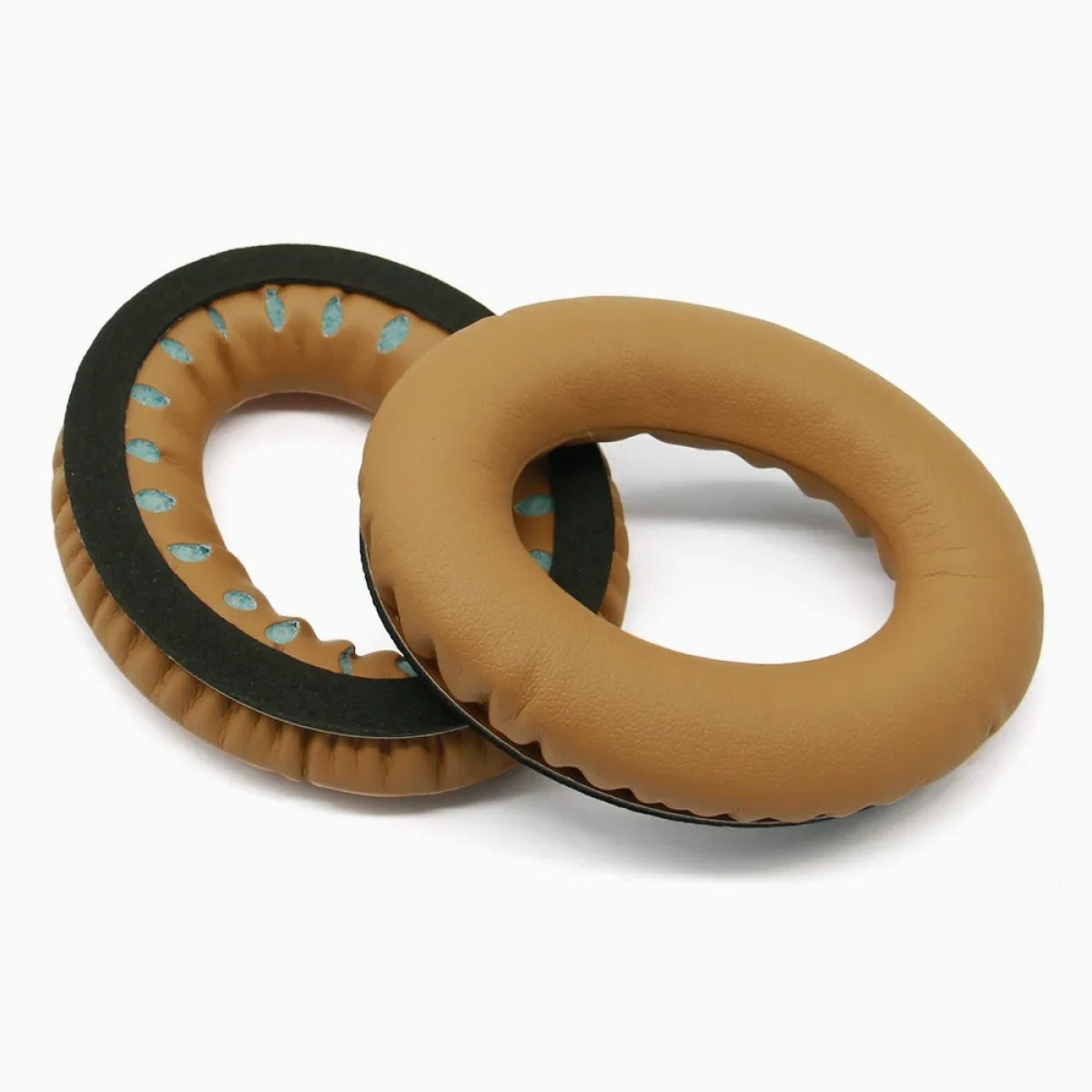 Dwie beżowe poduszki nauszne do słuchawek na białym tle.