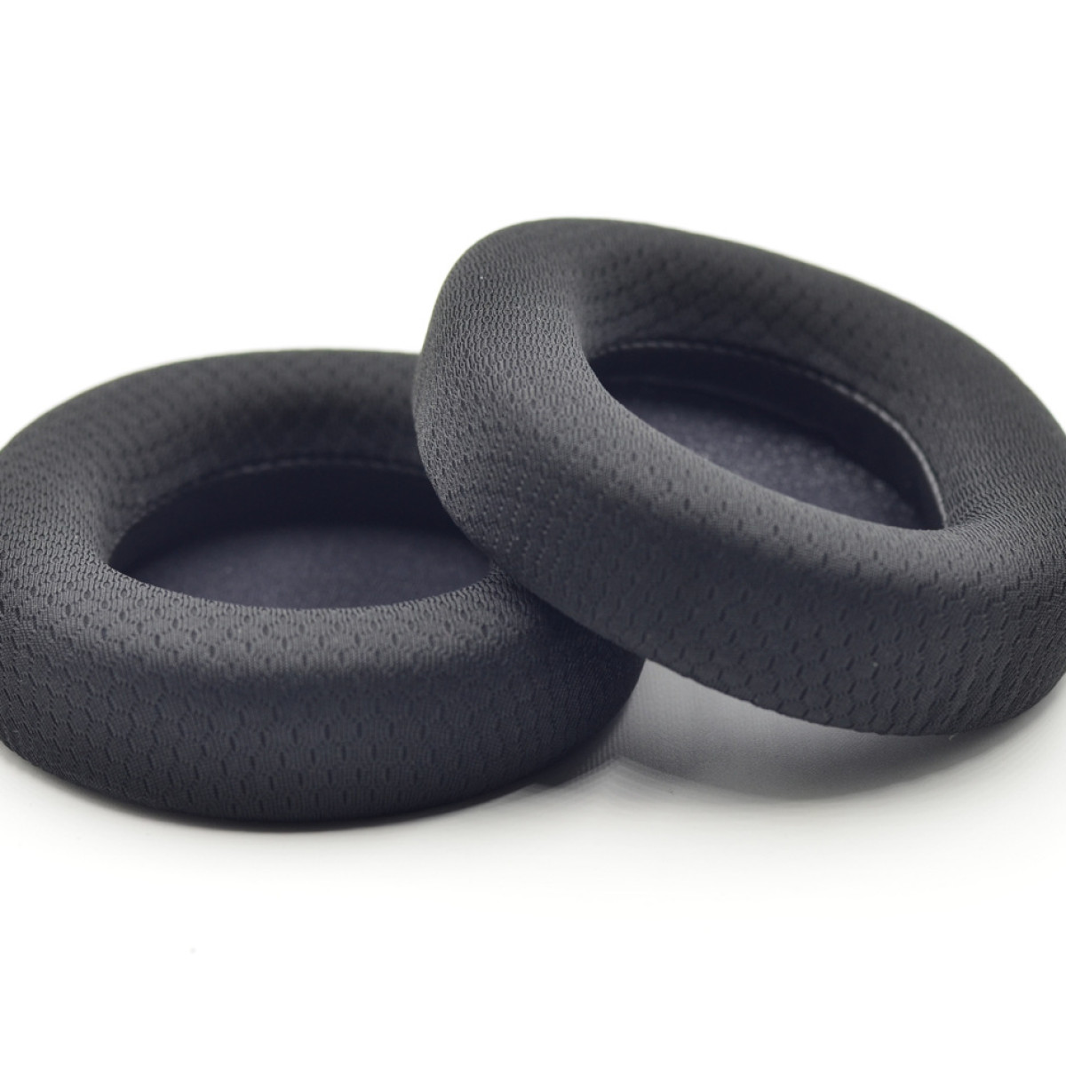 Dwie czarne nauszniki, wyizolowane na białym tle. Są okrągłe.