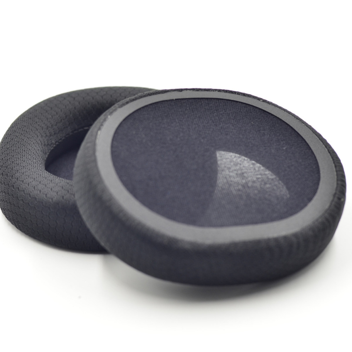 Dwie czarne poduszki na uszy. Jedna jest kompletna, druga otwarta, pokazująca materiał.