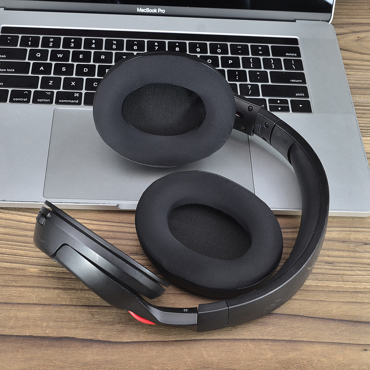 Cuffie nere su un laptop. Le cuffie sono aperte, mostrando i cuscinetti auricolari.