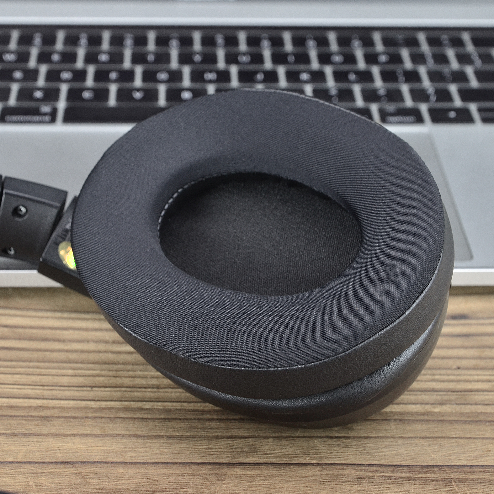 Cuscinetto auricolare nero su un laptop. Il cuscinetto è circolare e fatto di tessuto.