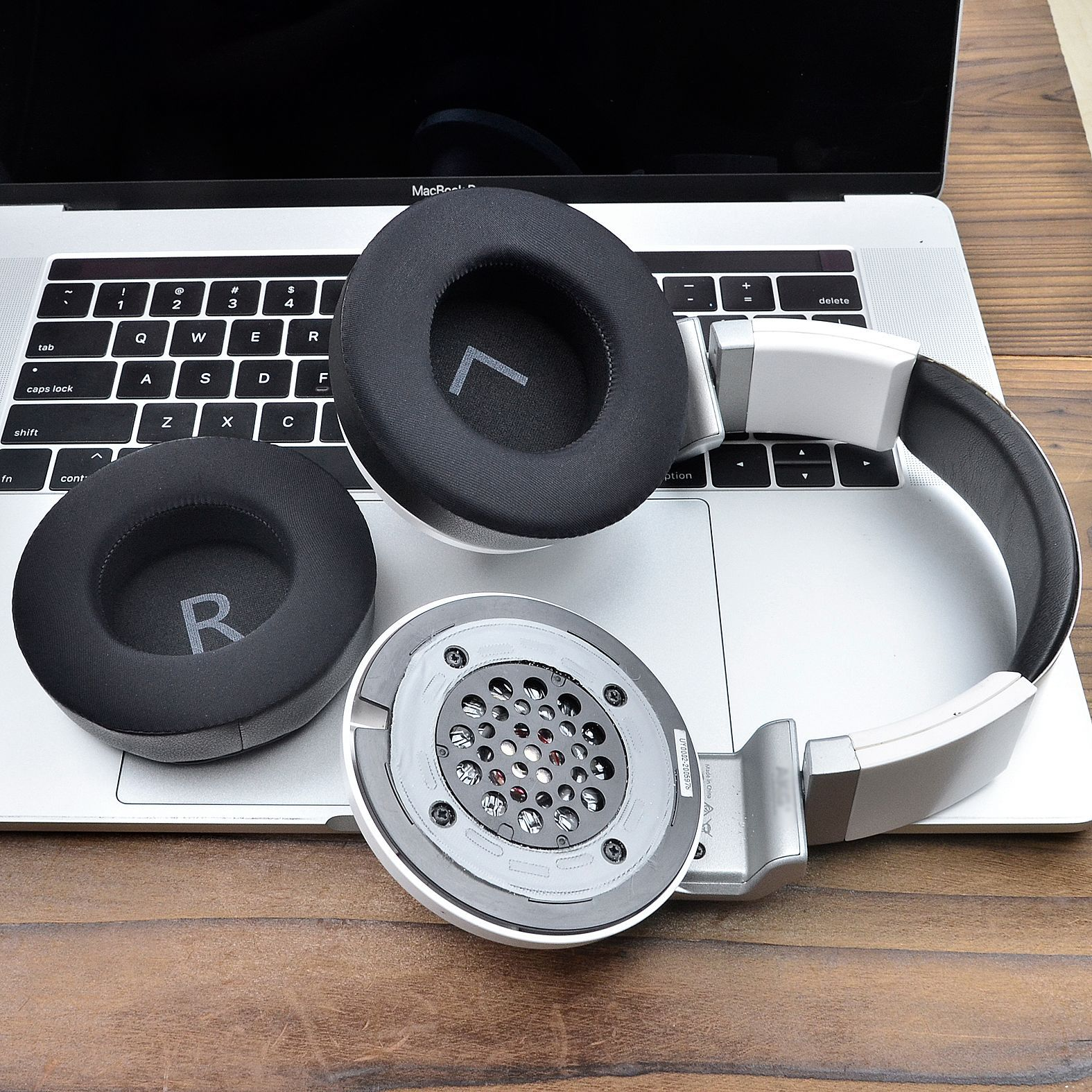 Słuchawki z nausznikami i poduszkami na laptopie i drewnianej powierzchni.