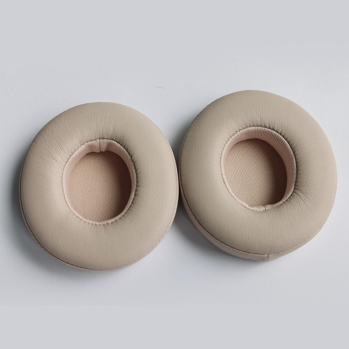 Set beige oorkussens, rond met een centrale opening.