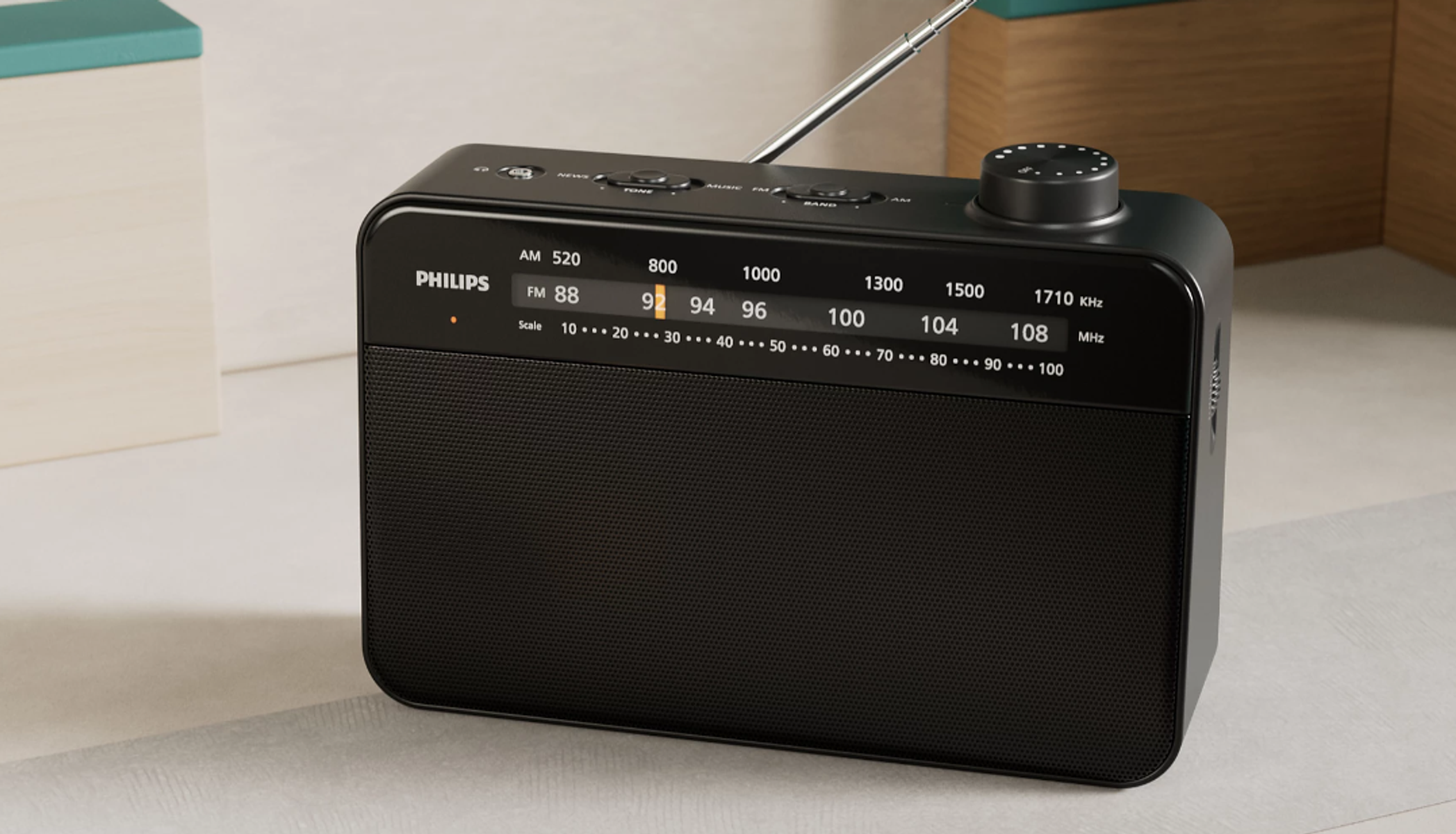 Czarny radio Philips z przyciskami i pokrętłem strojenia na jasnej powierzchni.