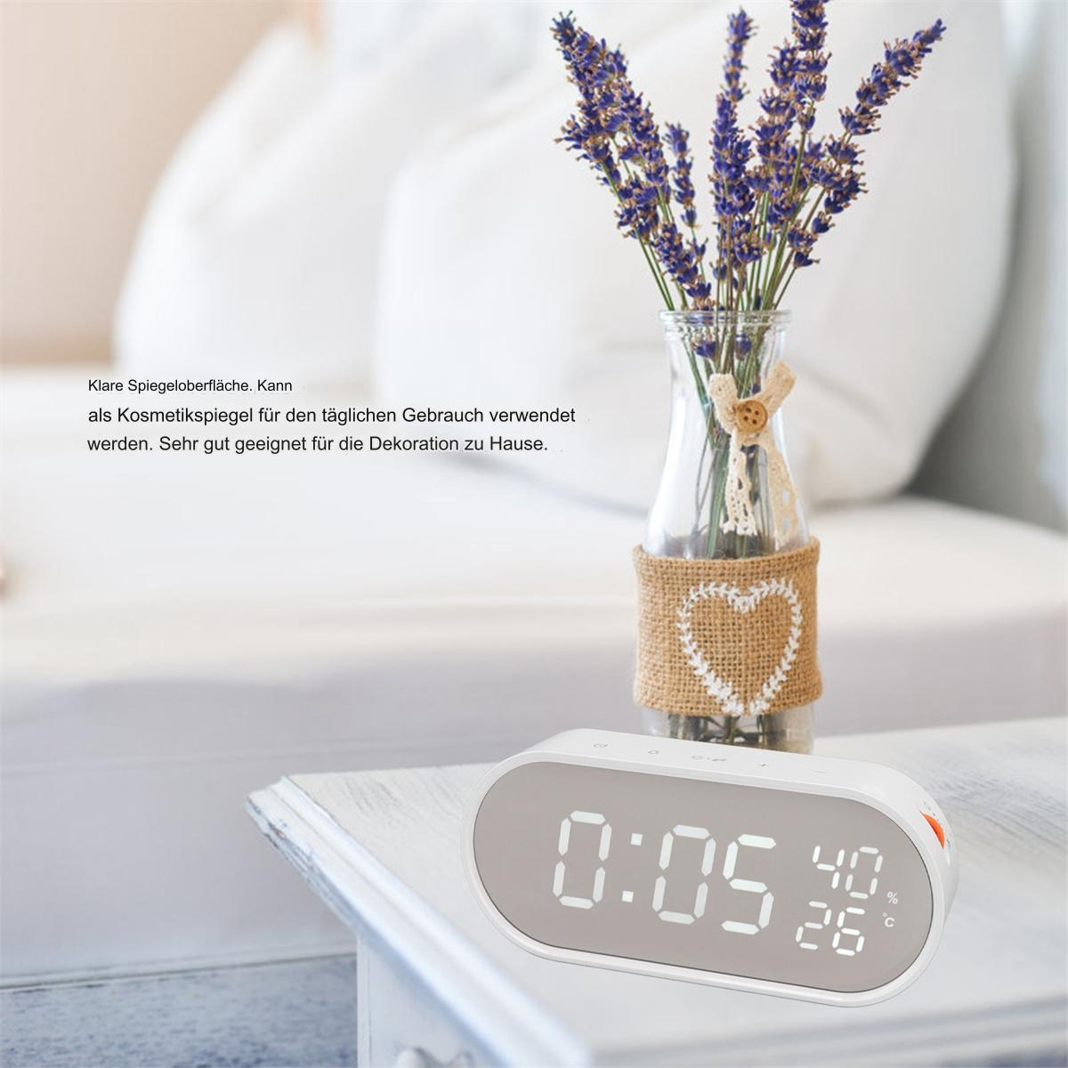 Wecker mit Digitalanzeige und Lavendel in Vase, auf weißem Tisch.