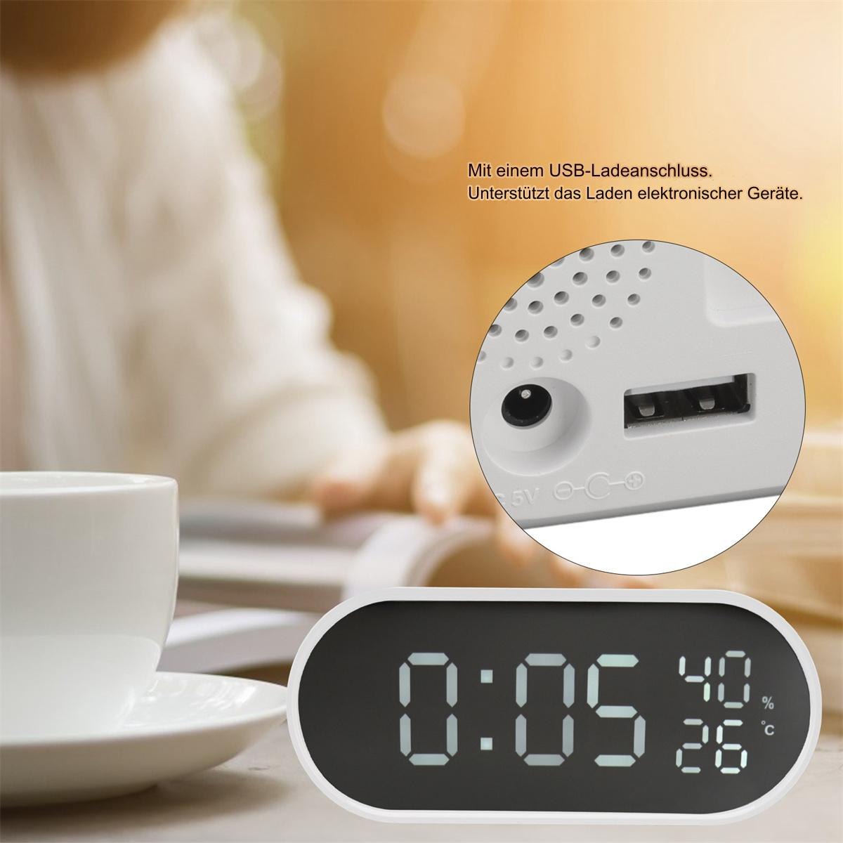 Eine Digitaluhr mit USB-Anschluss, die Zeit, Temperatur und Luftfeuchtigkeit anzeigt.