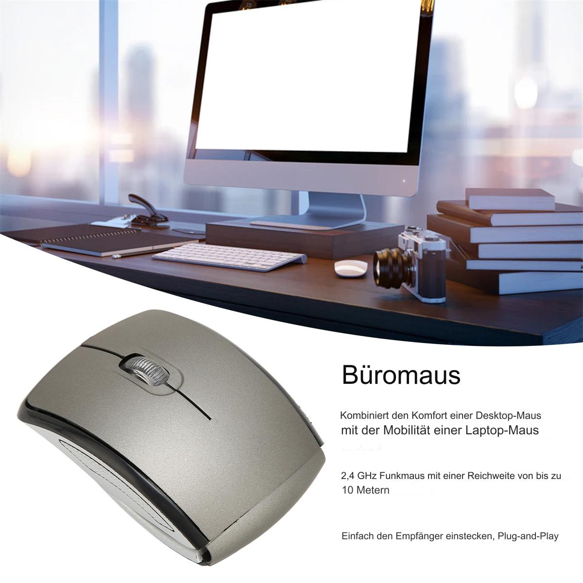 Eine silberne kabellose Maus auf einem Schreibtisch. Ein Computermonitor und Bücher sind im Hintergrund.
