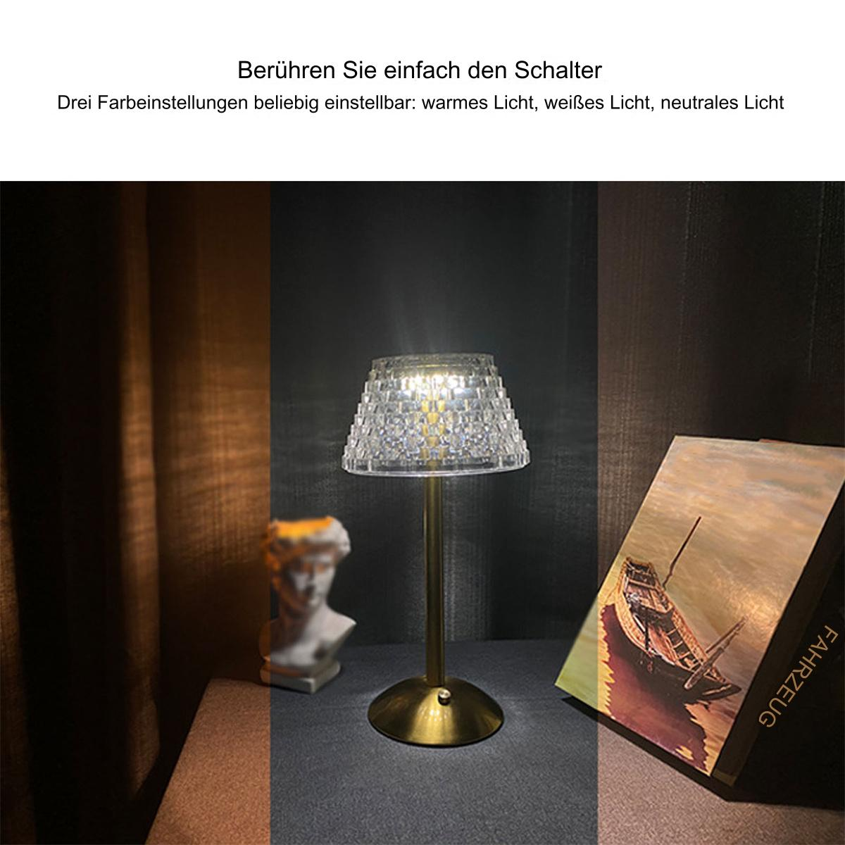 Tischlampe mit klarem Lampenschirm. Eine Büste und ein Buch befinden sich ebenfalls auf dem Tisch.