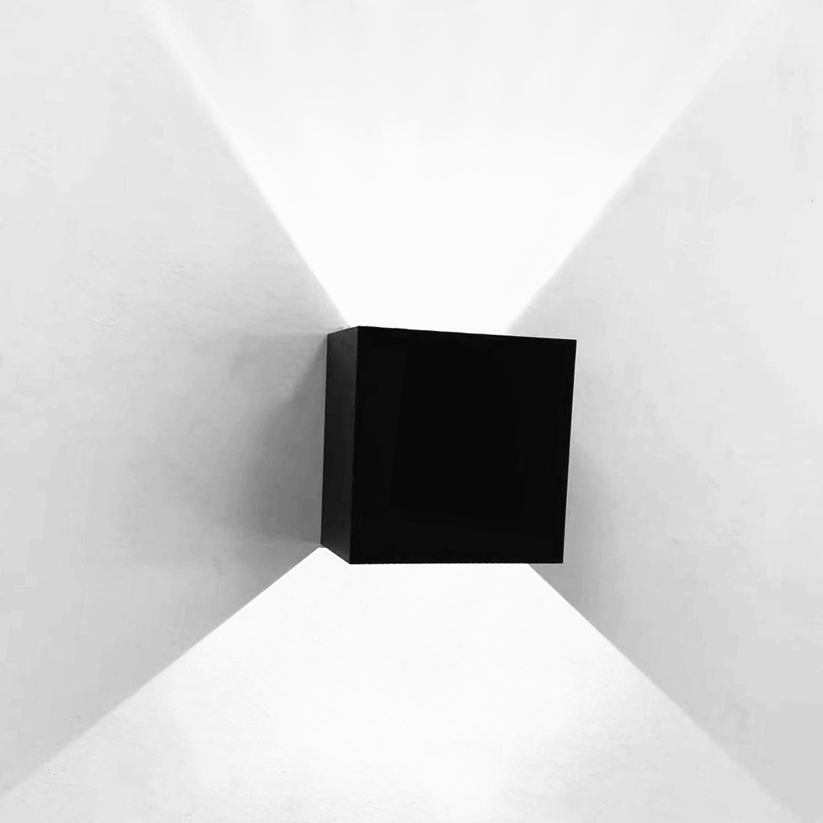 Schwarze quadratische Wandleuchte an weißer Wand mit Lichtstrahlen. Minimalistisches Design.