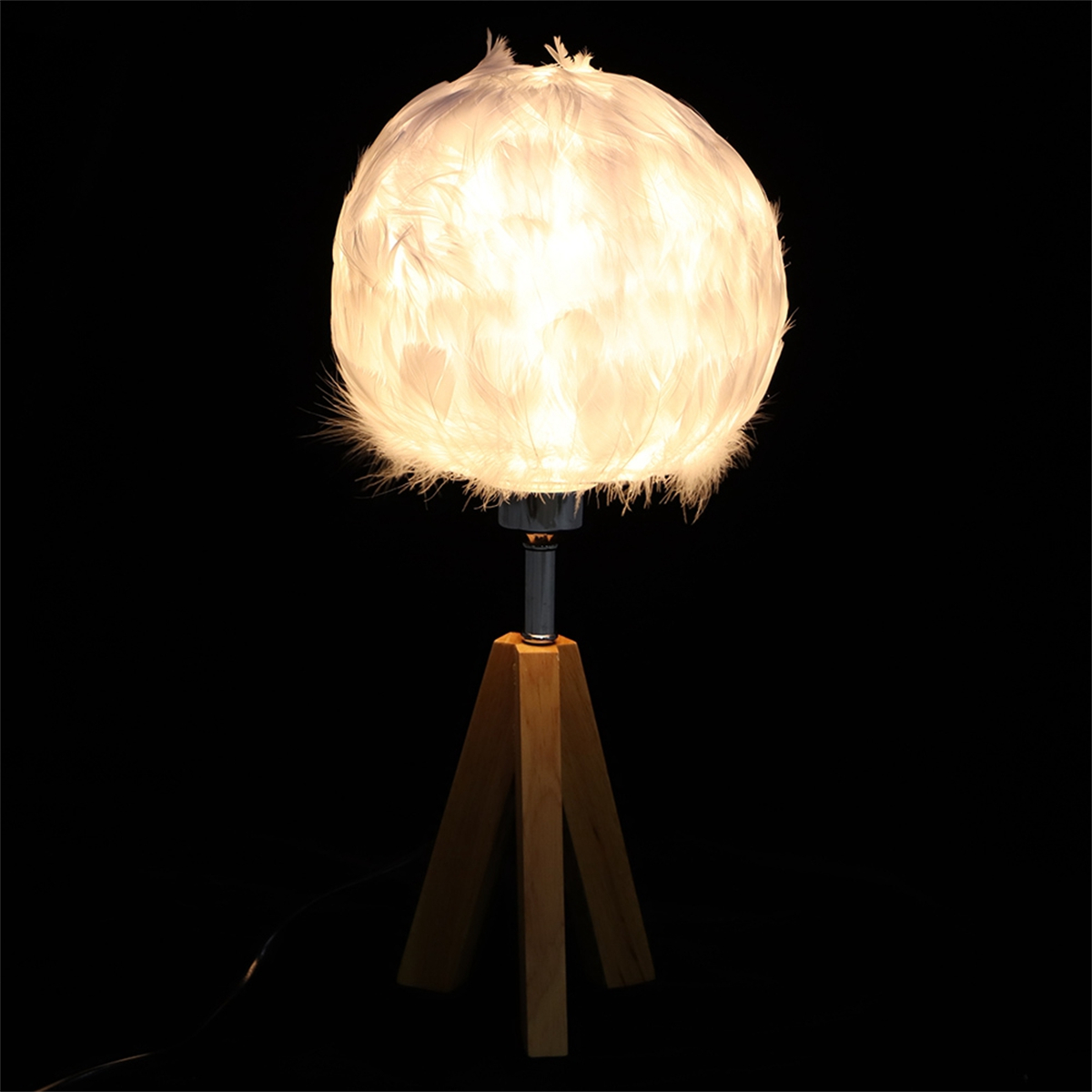 Eine Federlampe mit weißem Schirm auf einem Holzstativ vor schwarzem Hintergrund.