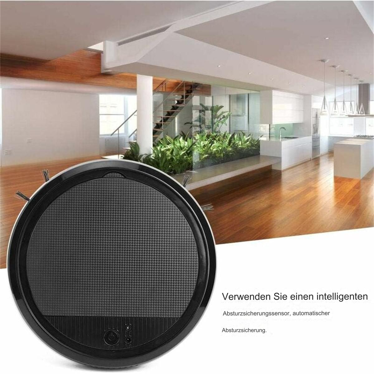 Ein schwarzer Roboter-Staubsauger auf einem Holzboden. Der Roboter ist rund mit einem dunkelgrauen Zentrum.