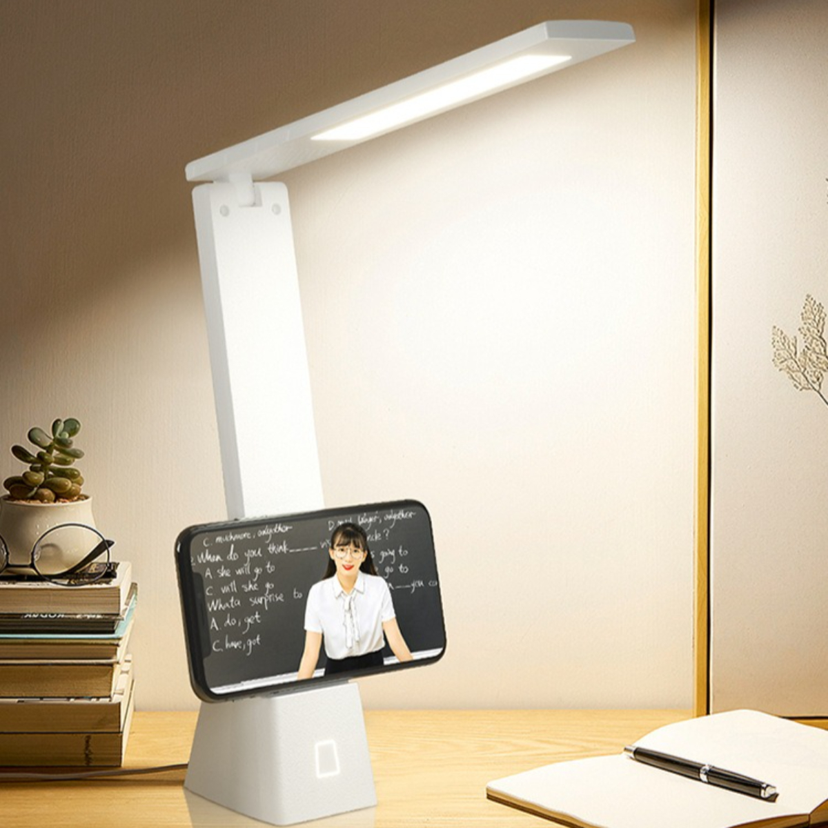 Weiße Schreibtischlampe mit Telefonhalter, zeigt eine Frau auf dem Bildschirm.