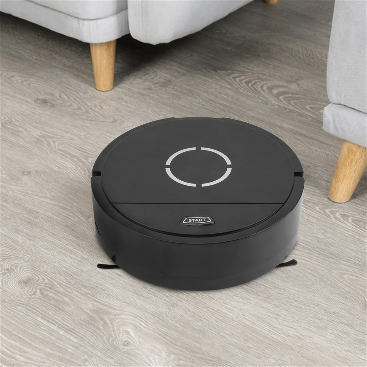 Schwarzer Roboter-Staubsauger auf einem Holzboden in einem Raum.