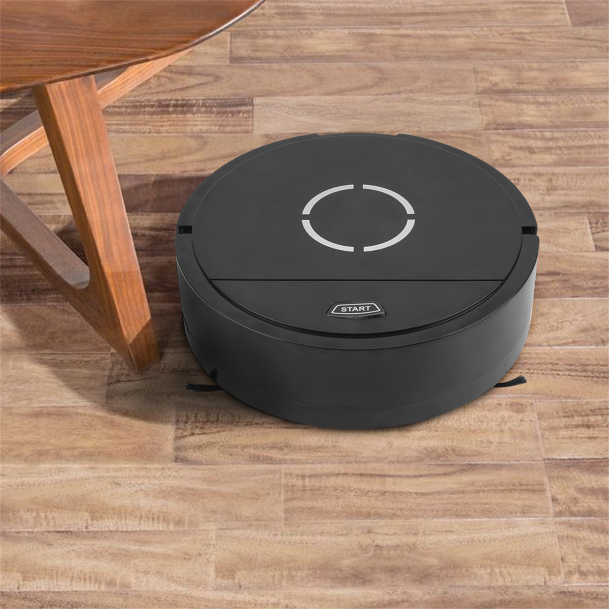 Schwarzer Roboter-Staubsauger auf Holzboden. Ein Stuhlbein in der Ecke.