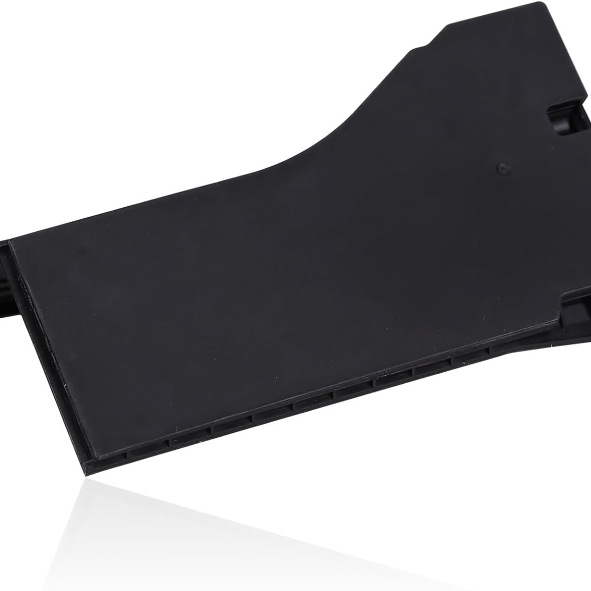 Czarna, prostokątna część z tworzywa sztucznego z lekko zakrzywioną powierzchnią wierzchnią.