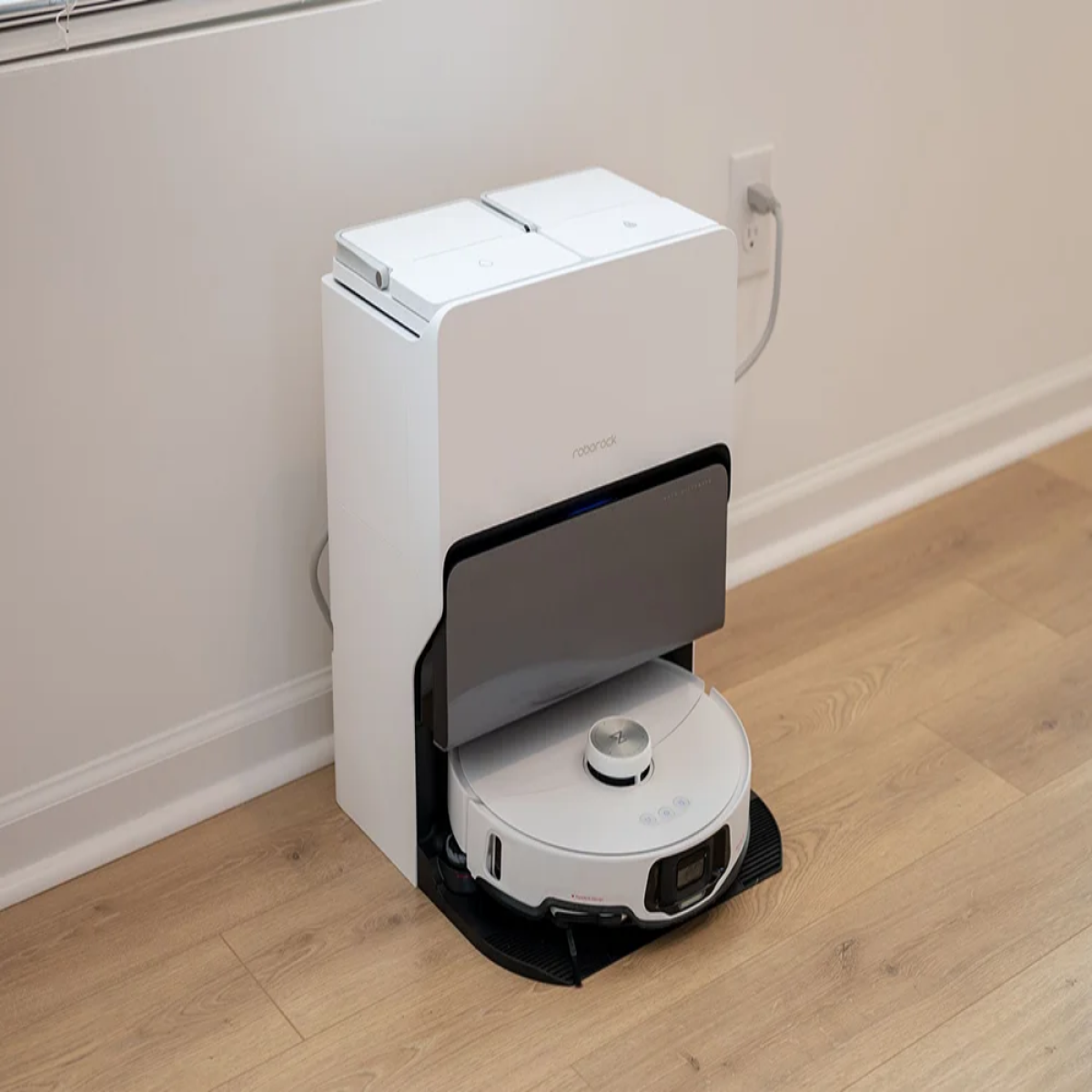 Weißer Roboter-Staubsauger und Dockingstation; die Station ist weiß mit einem Ladeanschluss.
