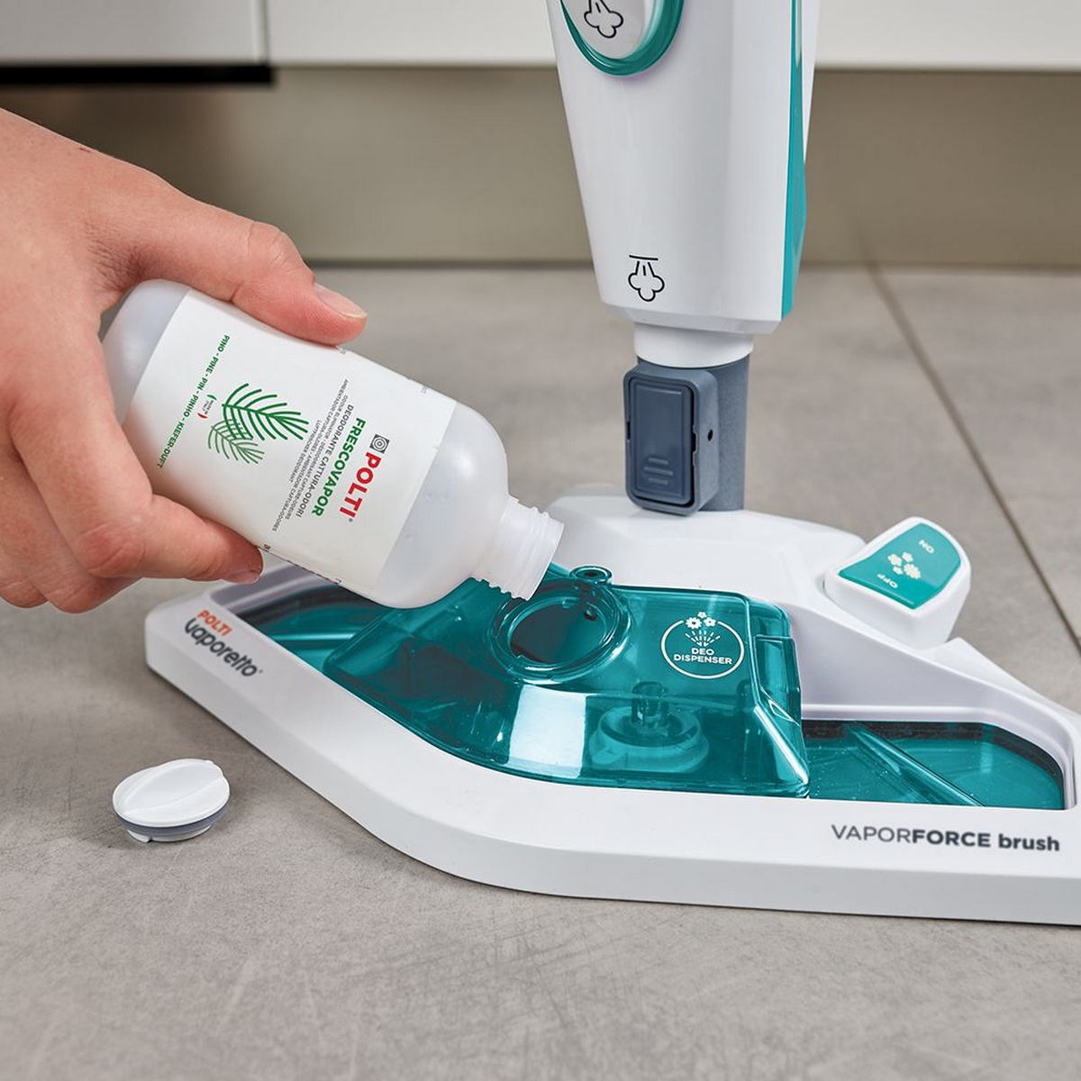 Ręka wylewająca płyn z butelki do głowicy czyszczącej mopa parowego.