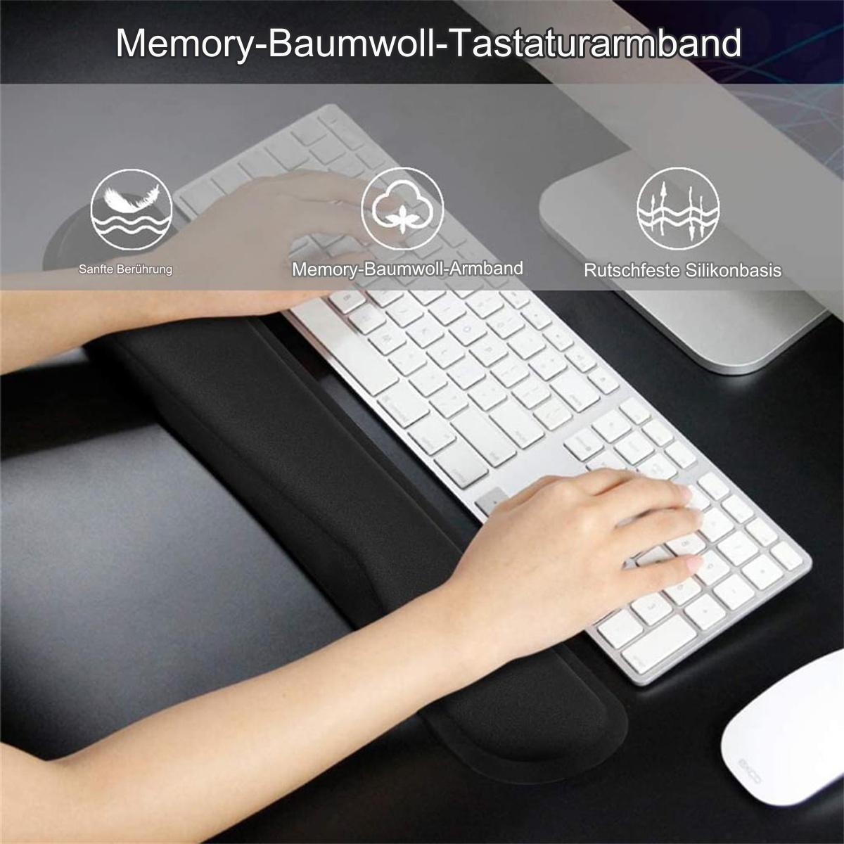 Eine Person benutzt eine Tastatur mit einer schwarzen Handgelenkauflage, einer Maus und einem Computermonitor.