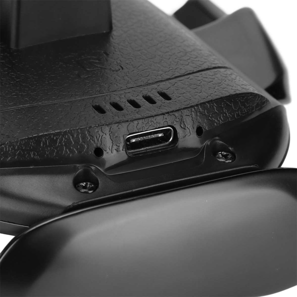 Nahaufnahme der Unterseite eines schwarzen Gamecontrollers mit USB-Anschluss.