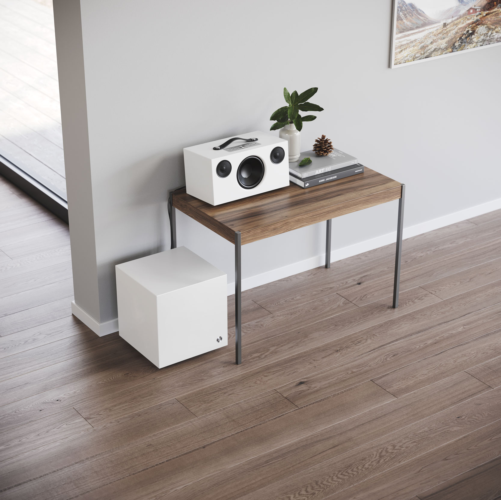 White speaker and subwoofer on a wooden table with a gray wall background.