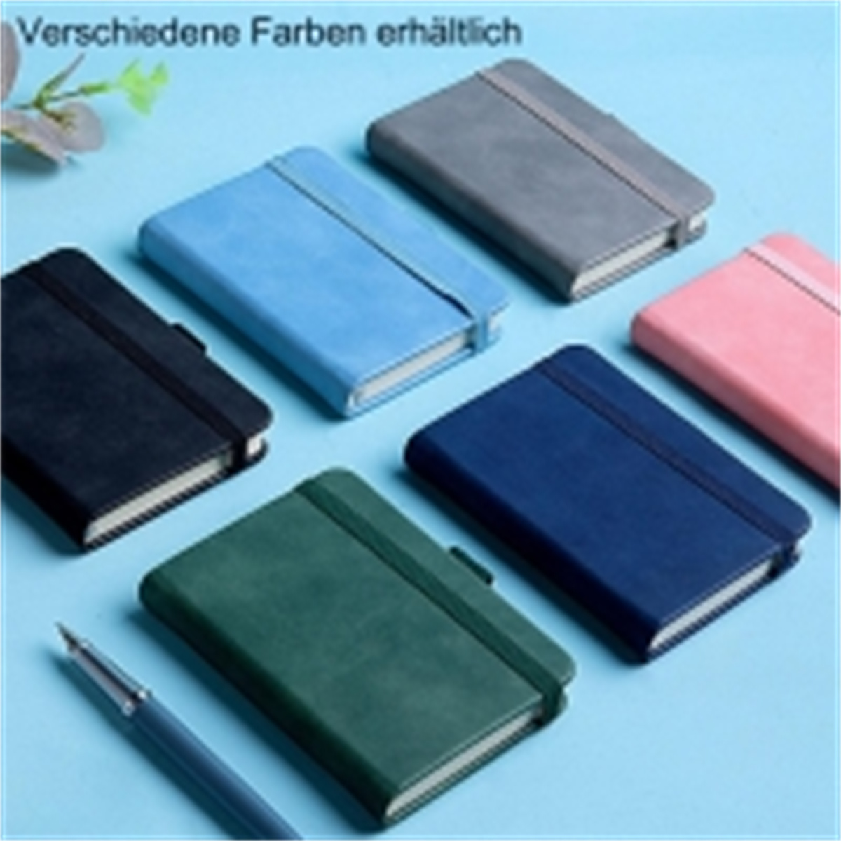 Notizbücher in verschiedenen Farben: schwarz, blau, grau, rosa, dunkelblau, grün. Blauer Stift auf blauem Hintergrund.