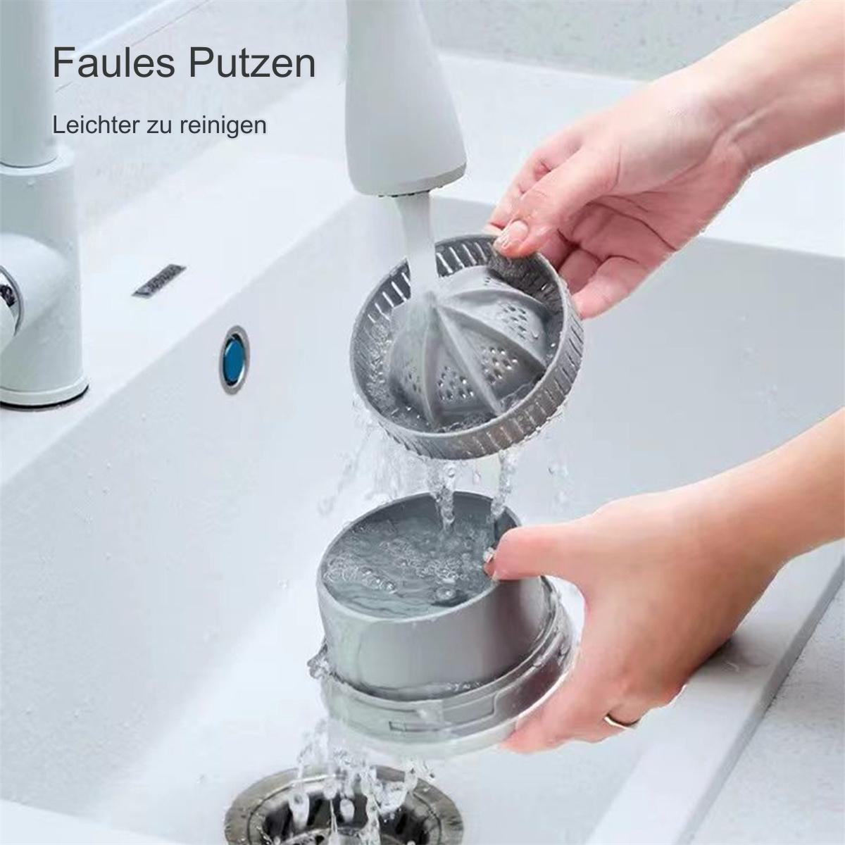 Hände halten einen Entsafter auseinander über einem Waschbecken, zeigen die abnehmbaren Teile.