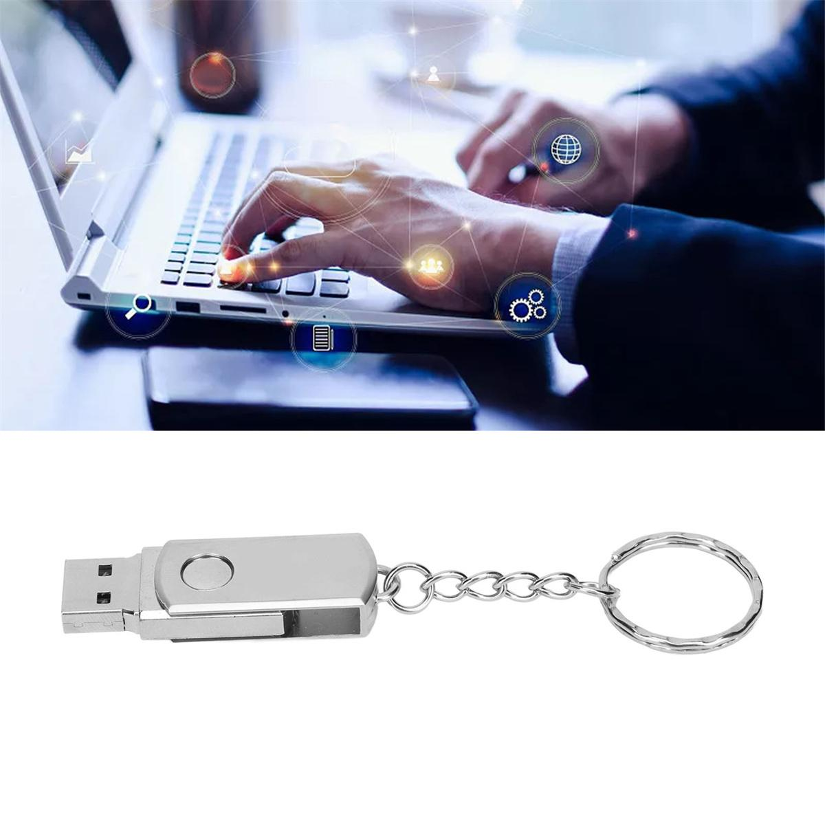 Ein silberner USB-Stick an einem Schlüsselanhänger neben einem Laptop mit Datentransfer.