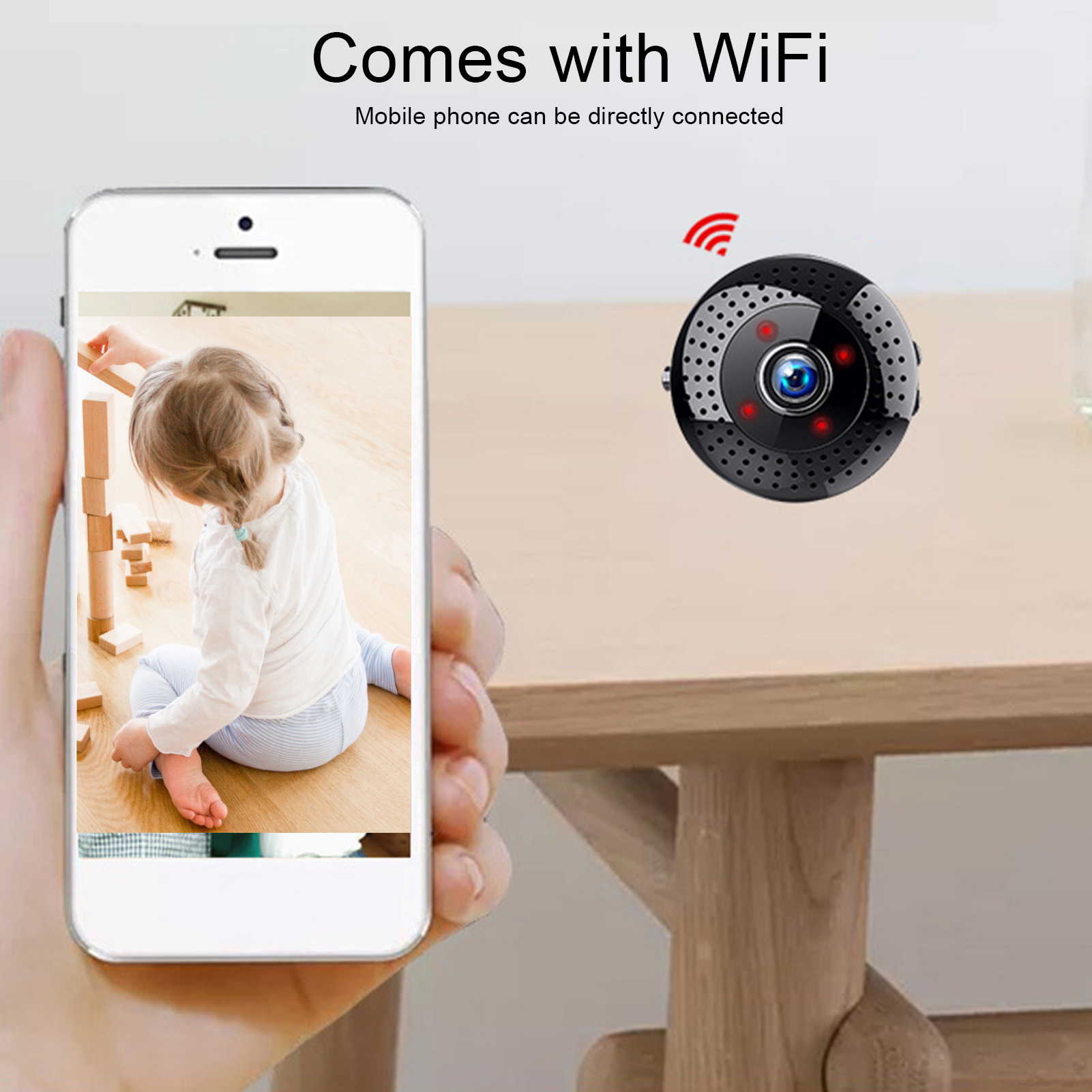 Ein Telefon zeigt das Bild eines Kindes. Eine kleine schwarze WLAN-Kamera ist in der Nähe.