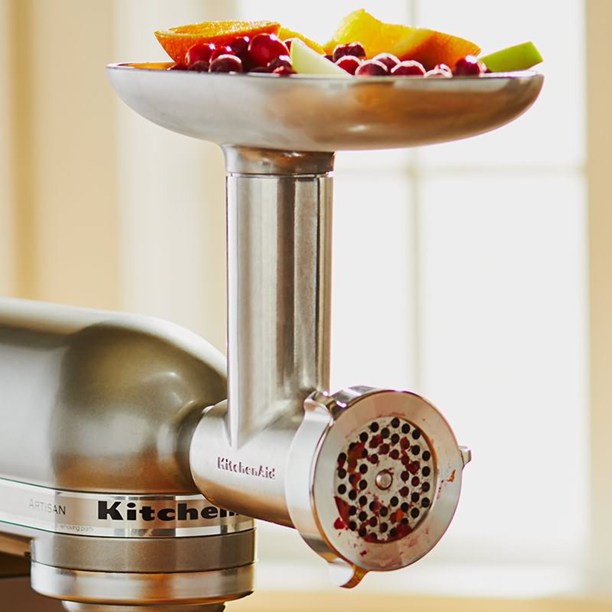 Een KitchenAid mixeropzetstuk met fruit in een kom, klaar voor verwerking.