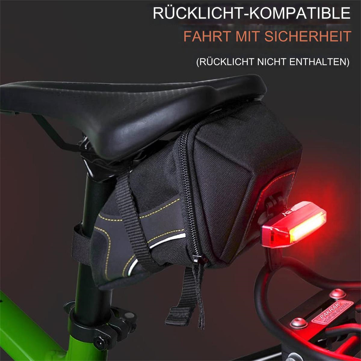 Schwarze Fahrradtasche mit rotem Licht, montiert an einem grünen Fahrrad.