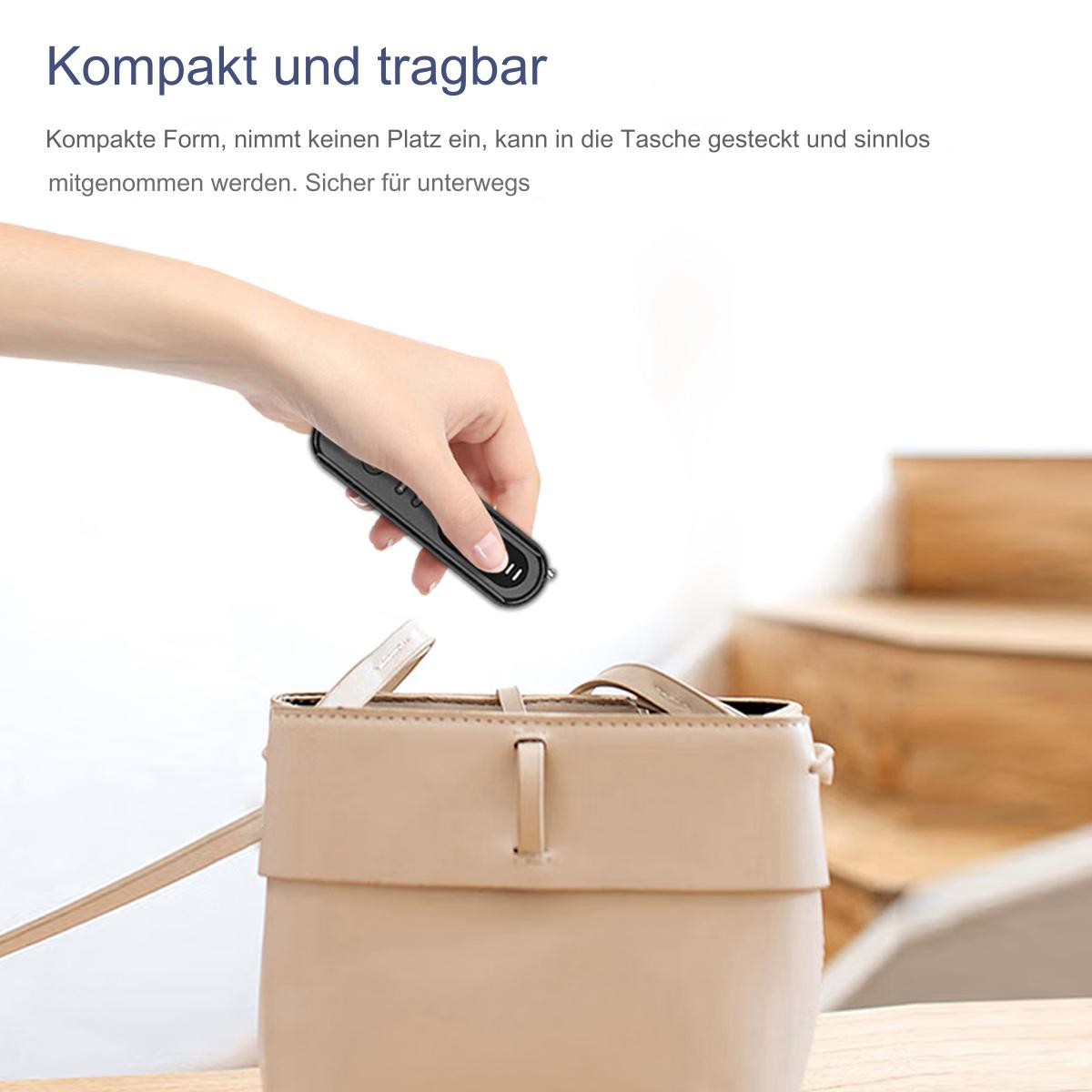 Die Hand einer Person, die ein kleines schwarzes Gerät in eine beige Handtasche legt.